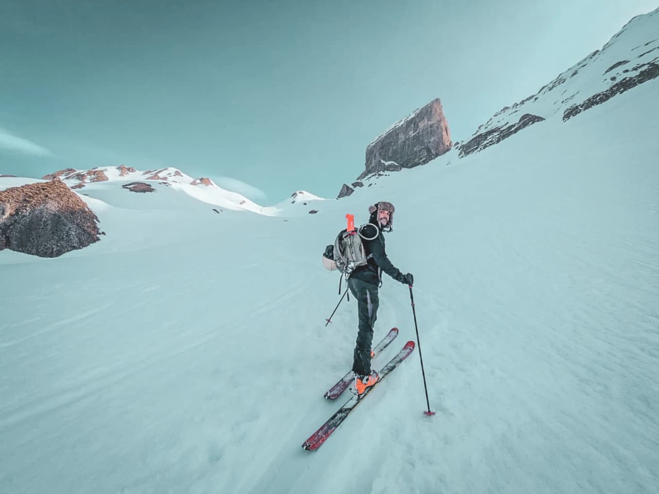 Ski touring on a glacier, with majestic mountains in the background and a clear sky.