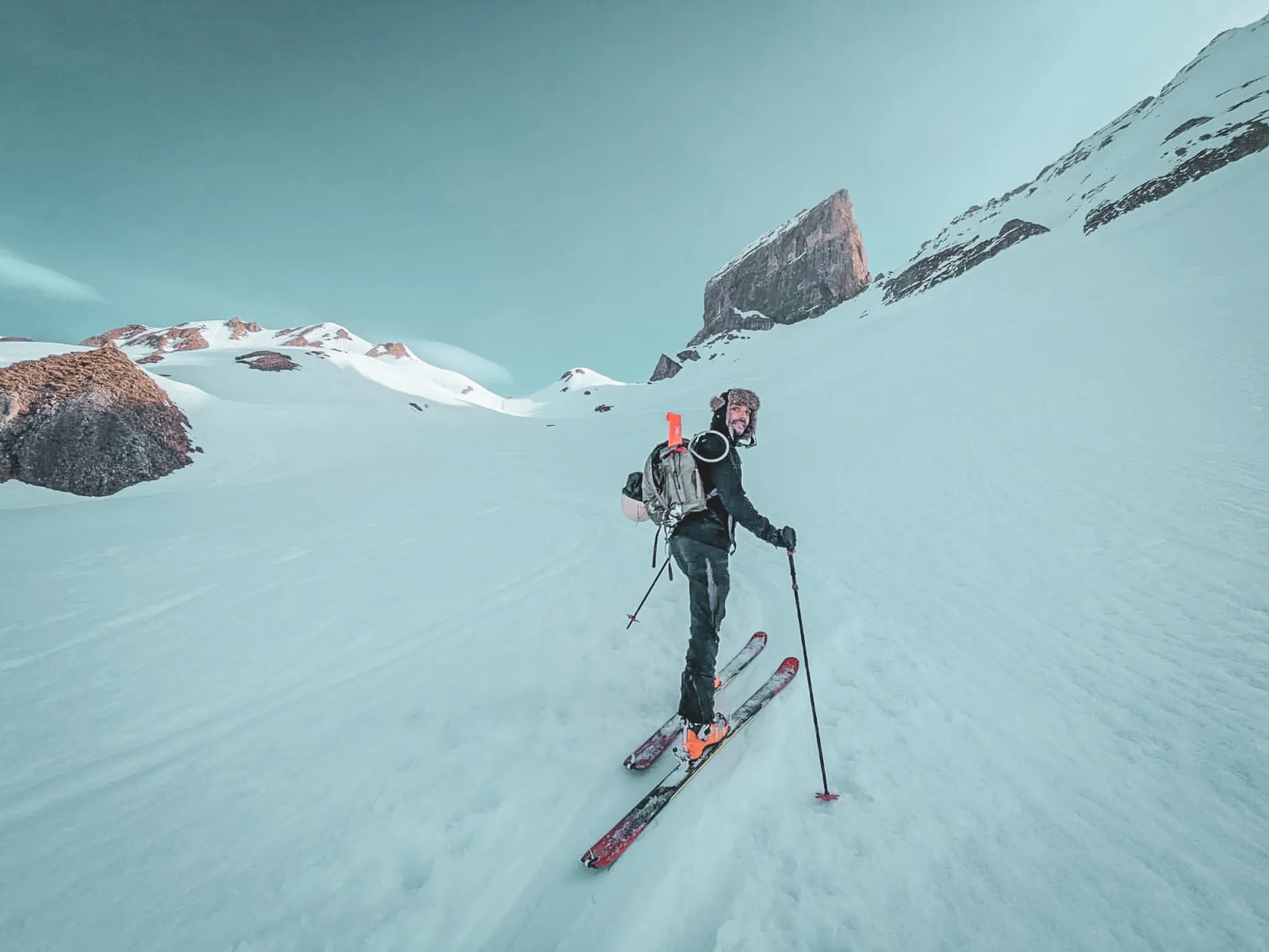 Ski touring on a glacier, with majestic mountains in the background and a clear sky.