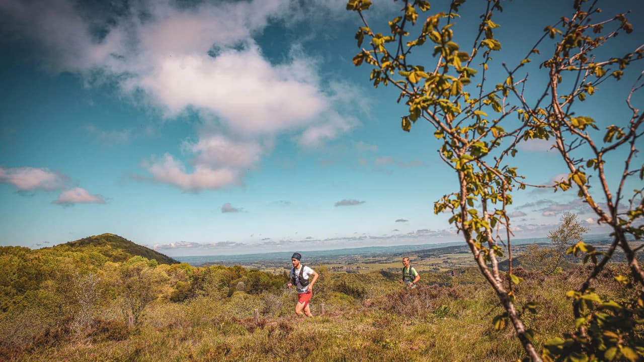 Two runners in the heart of the Auvergne countryside, surrounded by magnificent volcanic landscapes.