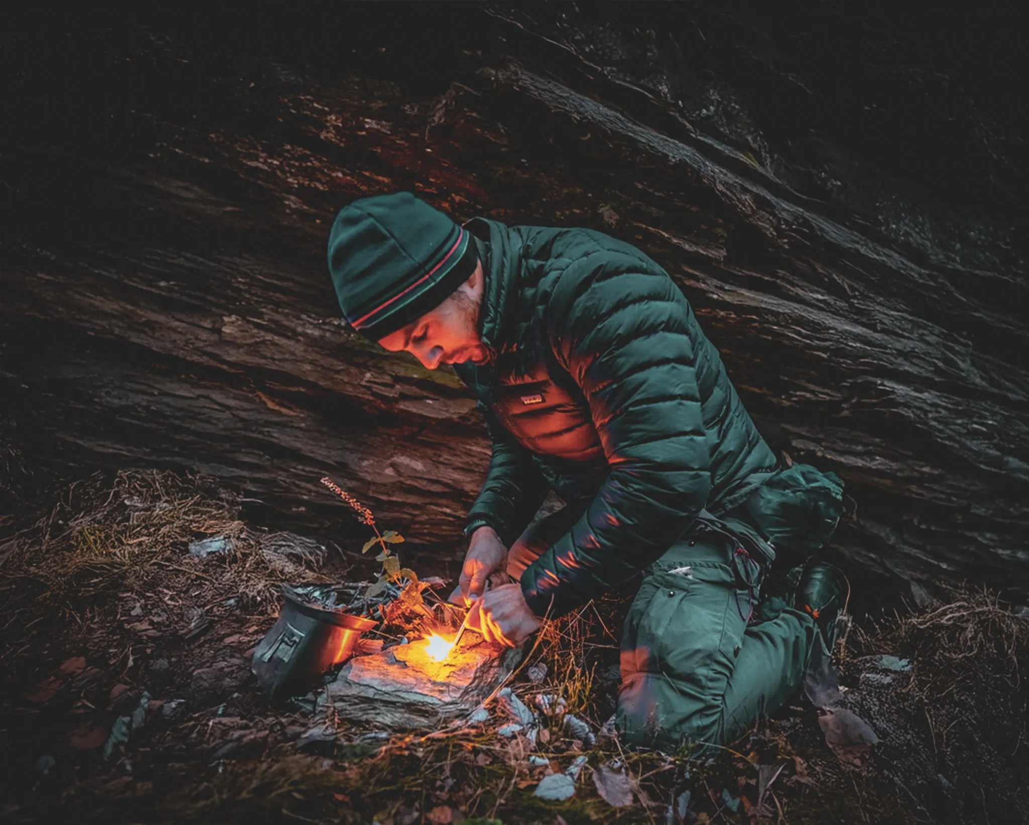 An adventurer lights a fire in the heart of the forests of the Vercors, a warm atmosphere and wild nature.