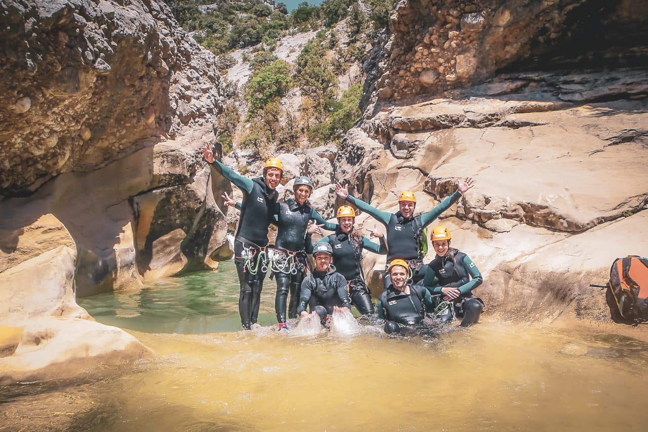 Enthusiastic group in canyoning suits in a sunny canyon in the Sierra de Guara.