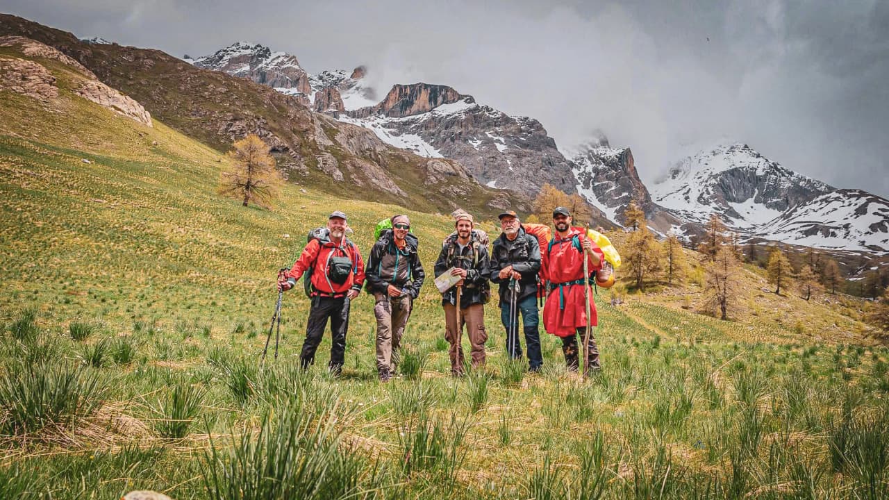 Groupe d'aventuriers en pleine nature, montagnes enneigées en arrière-plan, ambiance conviviale.