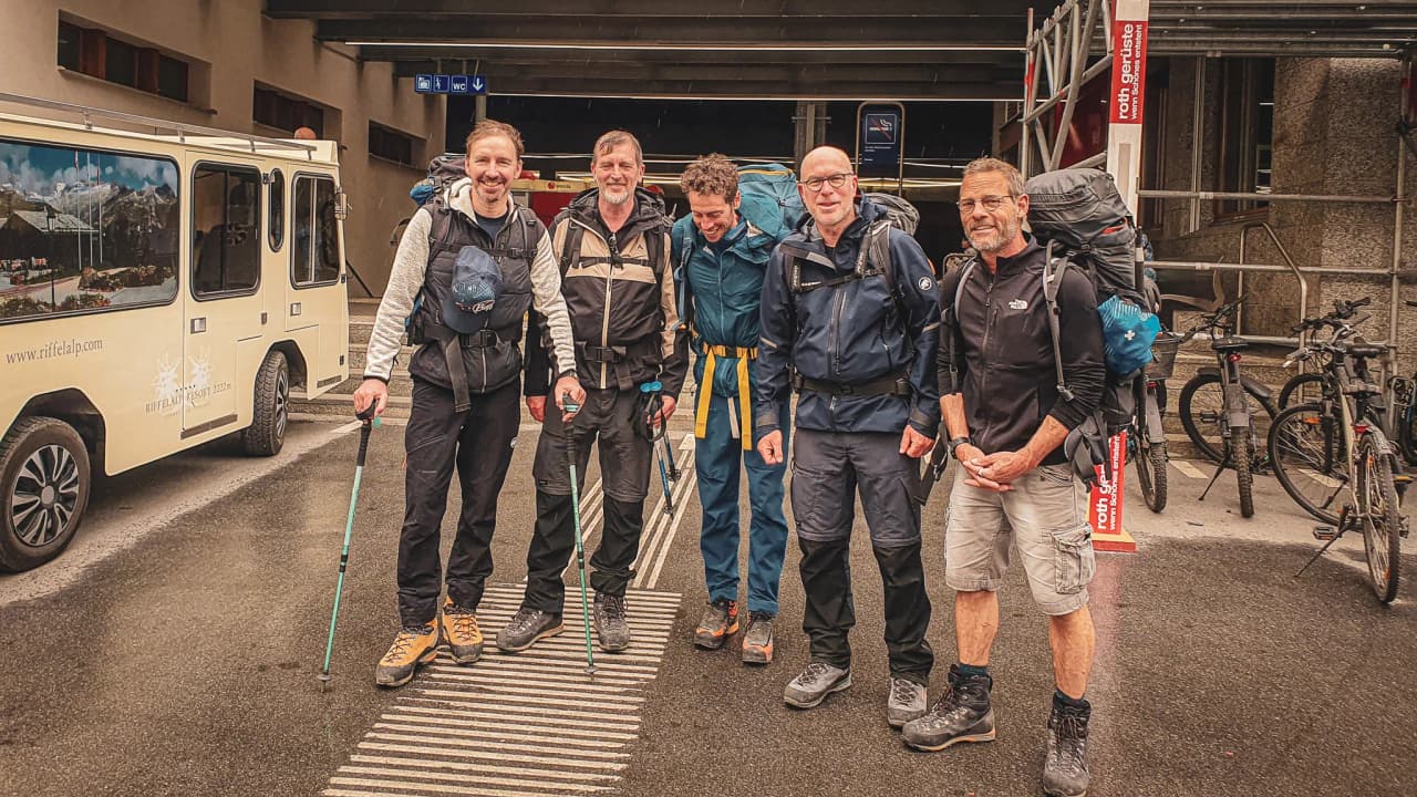 Five smiling adventurers prepare for a glacier expedition in the Alps.