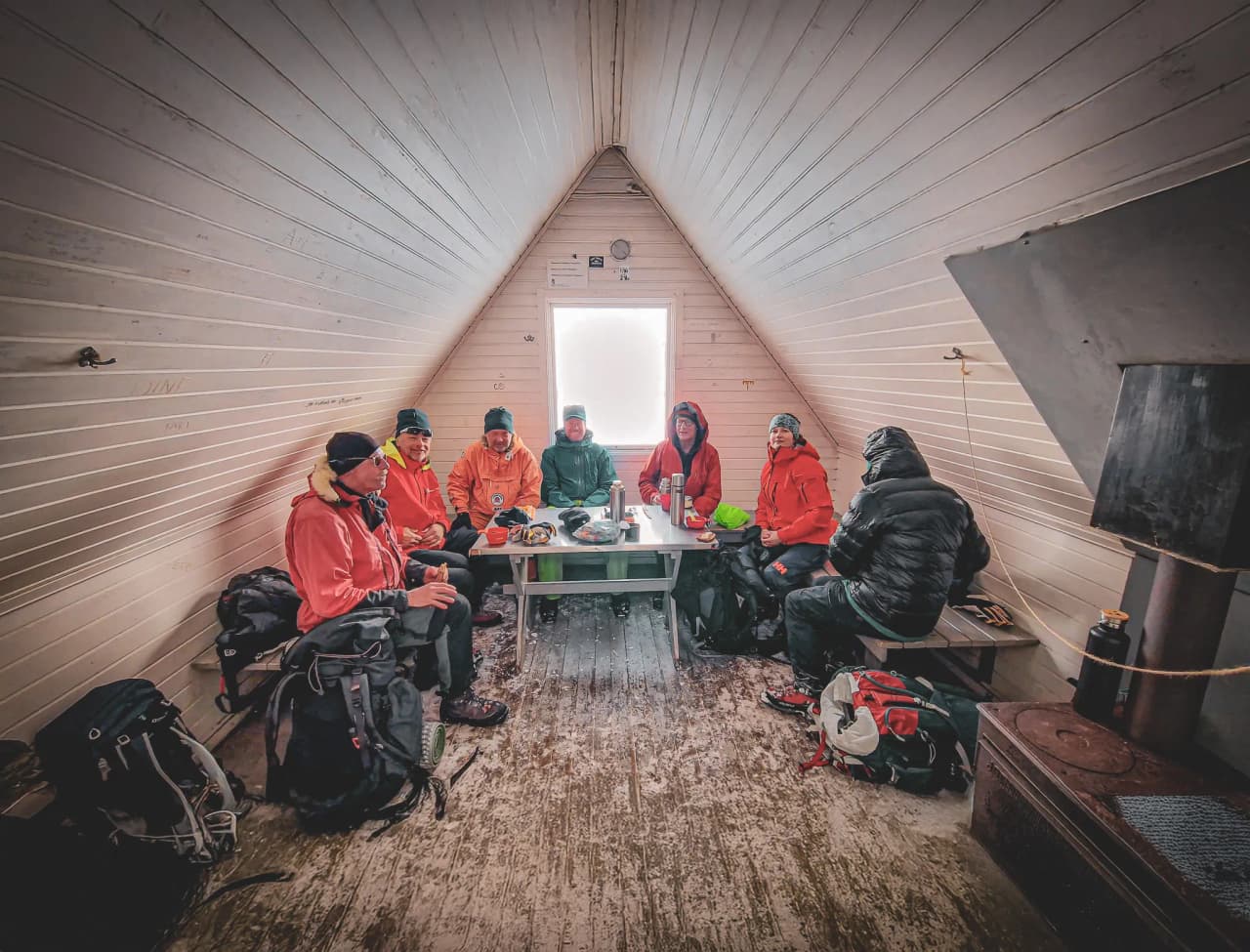 Een groep wandelaars rust uit in een gezellig Berghut na een dag skiën in Lapland.