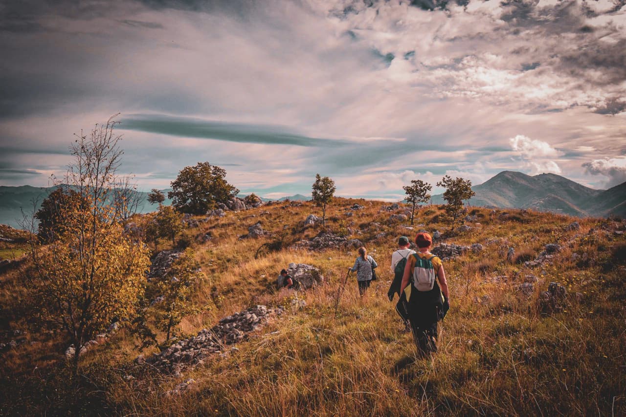 Een groep wandelaars verkent de gouden heuvels van de Valle di Comino onder een heldere hemel.