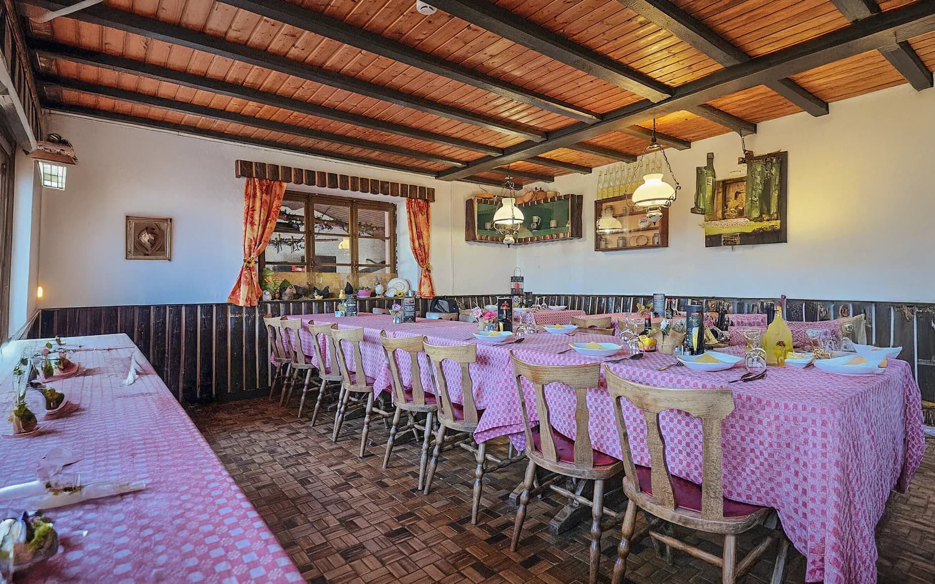 Salle chaleureuse avec tables à carreaux roses, prête à accueillir des randonneurs des Vosges.