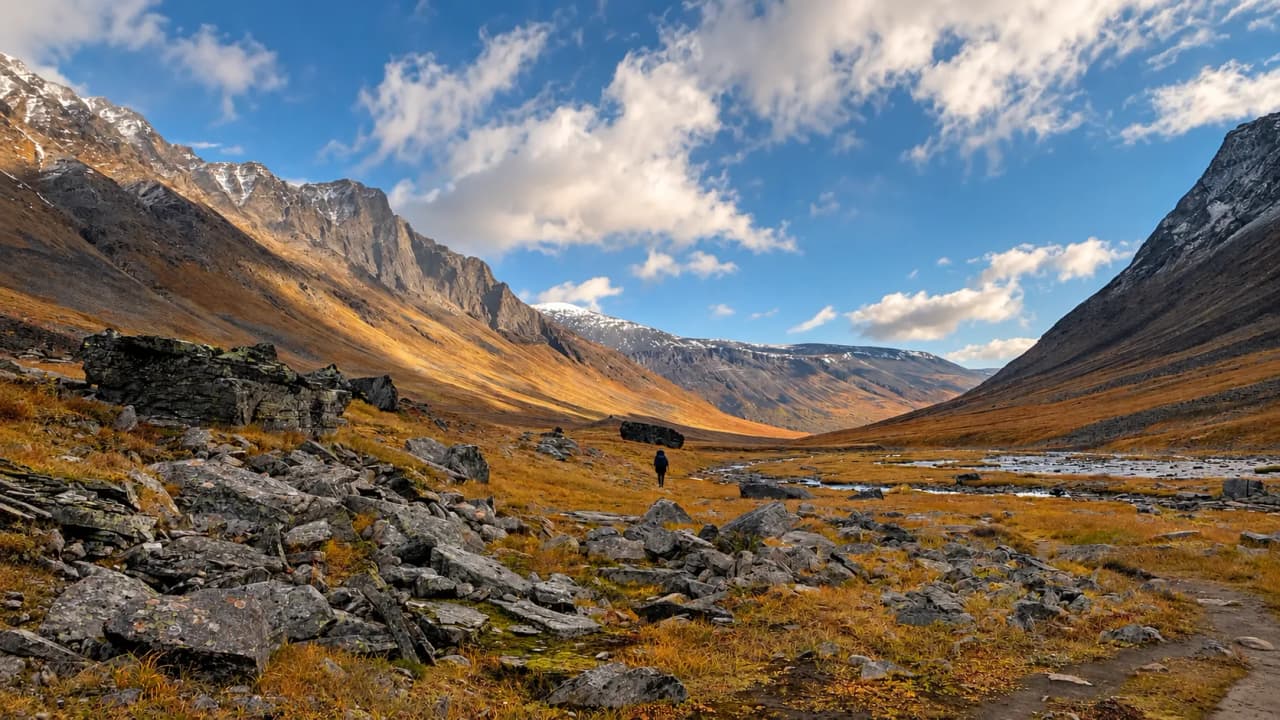 Une vaste vallée de Laponie suédoise, parsemée de rochers et de paysages montagneux majestueux.