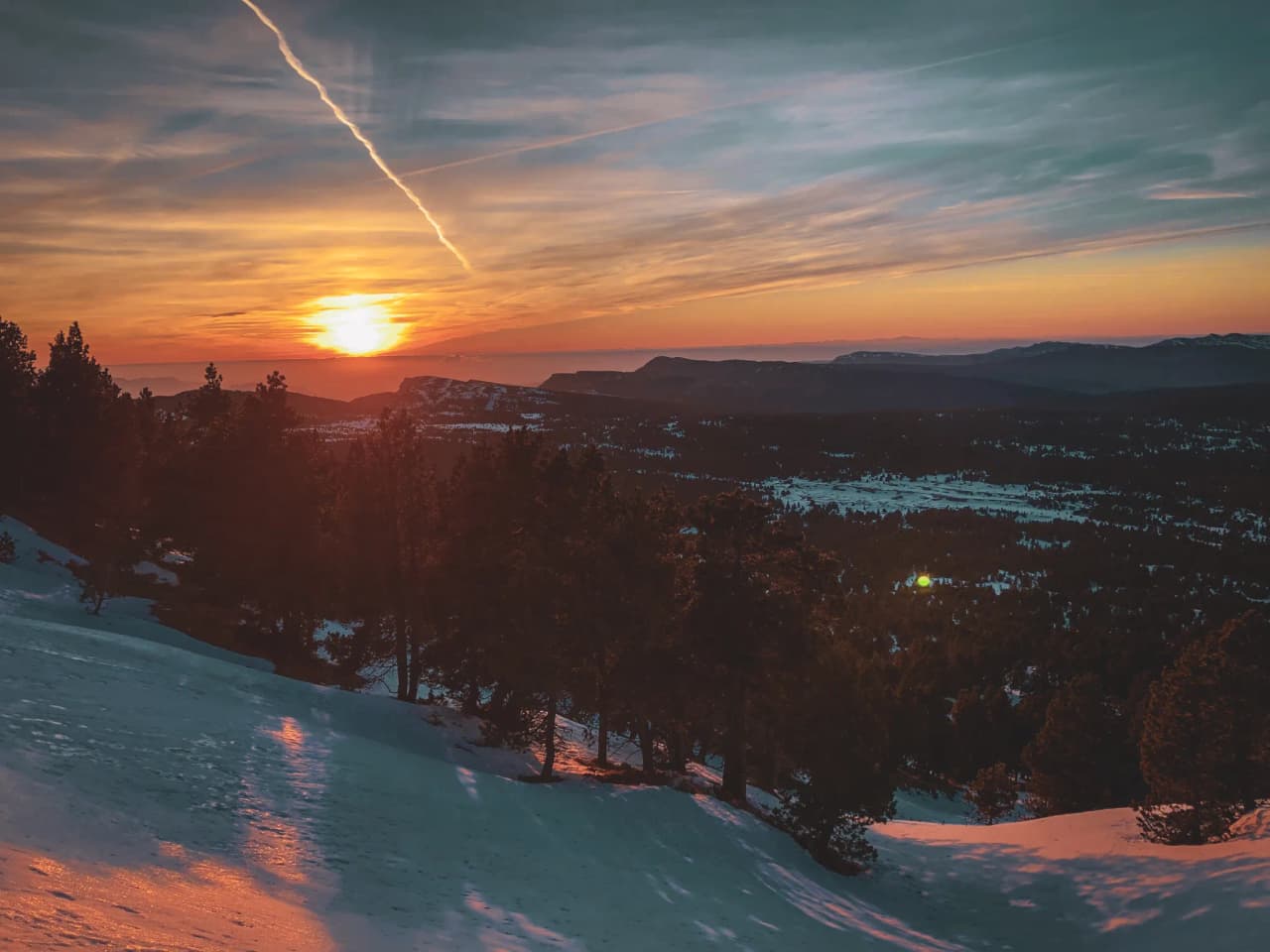 A vibrant sunset over the snow-capped mountains of the Vercors, an invitation to adventure.