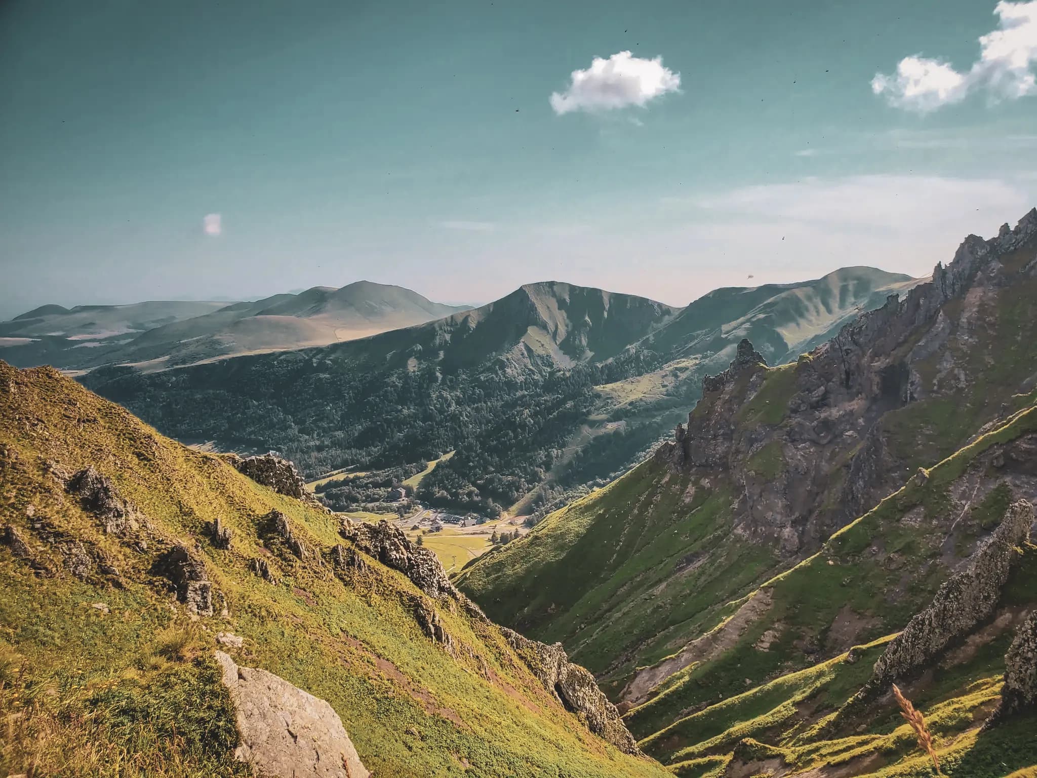 Panoramisch uitzicht op de vulkanen van de Auvergne, weelderig groene valleien en majestueuze landschappen.