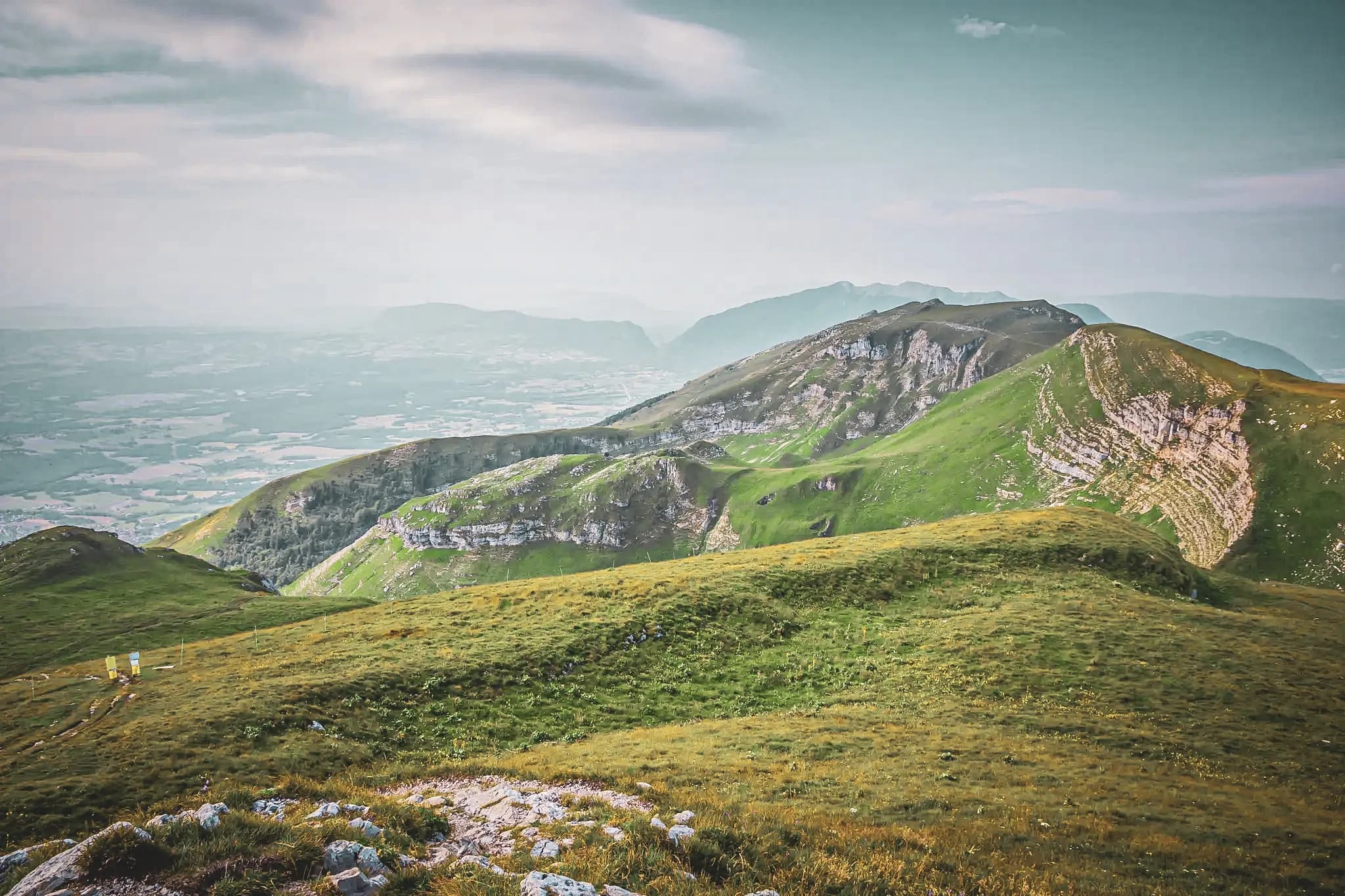 Panorama verdoyant des crêtes du Haut-Jura, invitant à l'aventure et à la découverte.