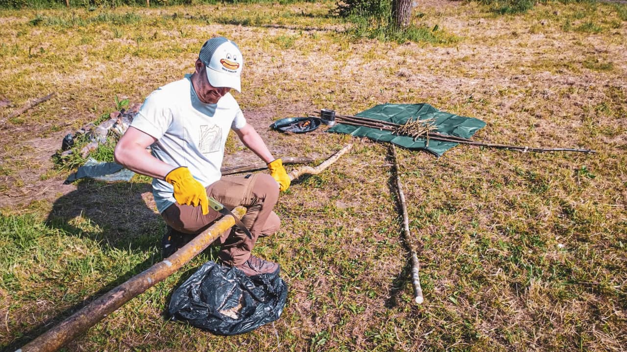 Un homme en pleine nature, préparant du bois sous un soleil radieux, prêt pour l'aventure.