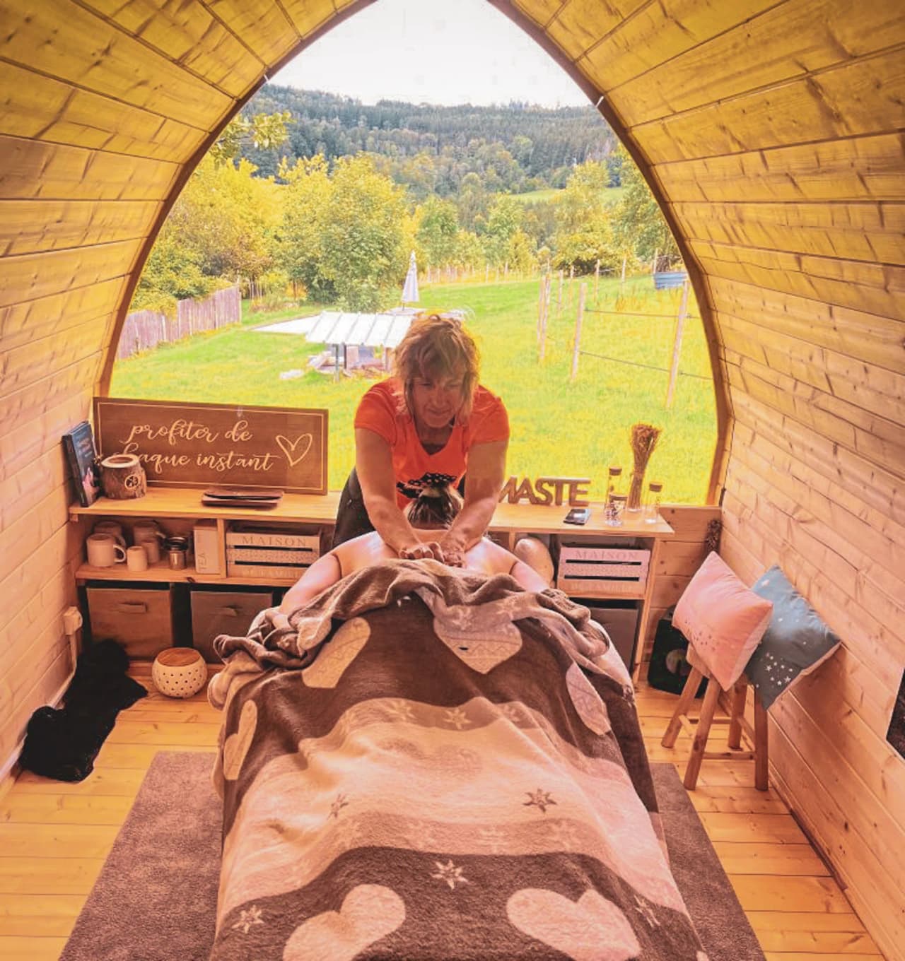 Een zen-ruimte met een therapeut die een massage aanbiedt, omgeven door weelderig groen.