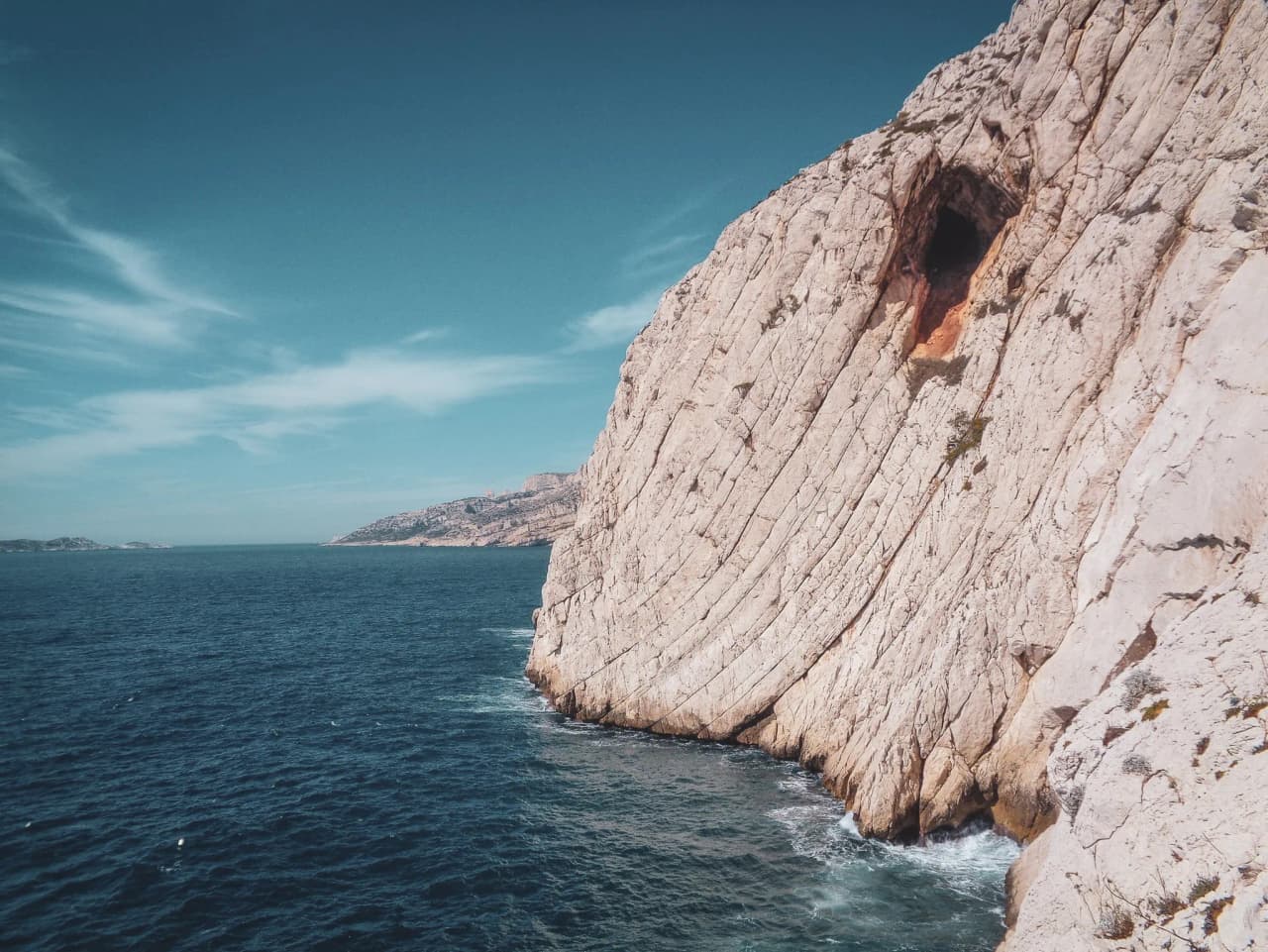 Falaises de calcaire surplombant une mer bleu azur, invitant à l'aventure en Méditerranée.