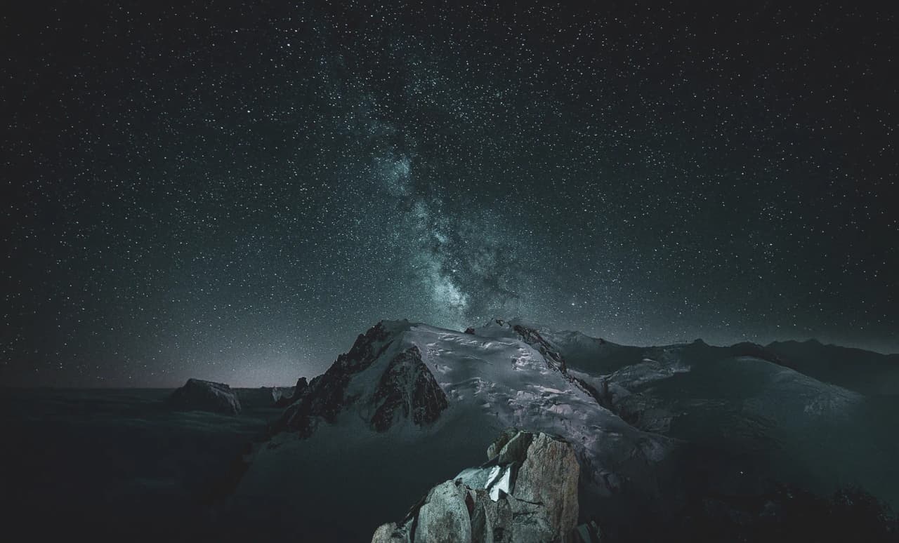 Starry skies over snow-capped peaks, an invitation to climb Mont Blanc.