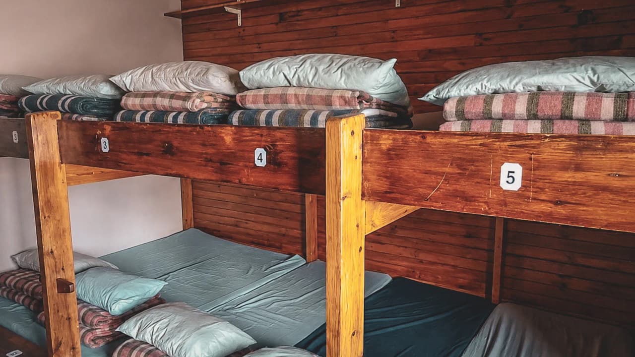 Lit superposé en bois dans un chalets montagnard, prêt pour une aventure alpiniste.
