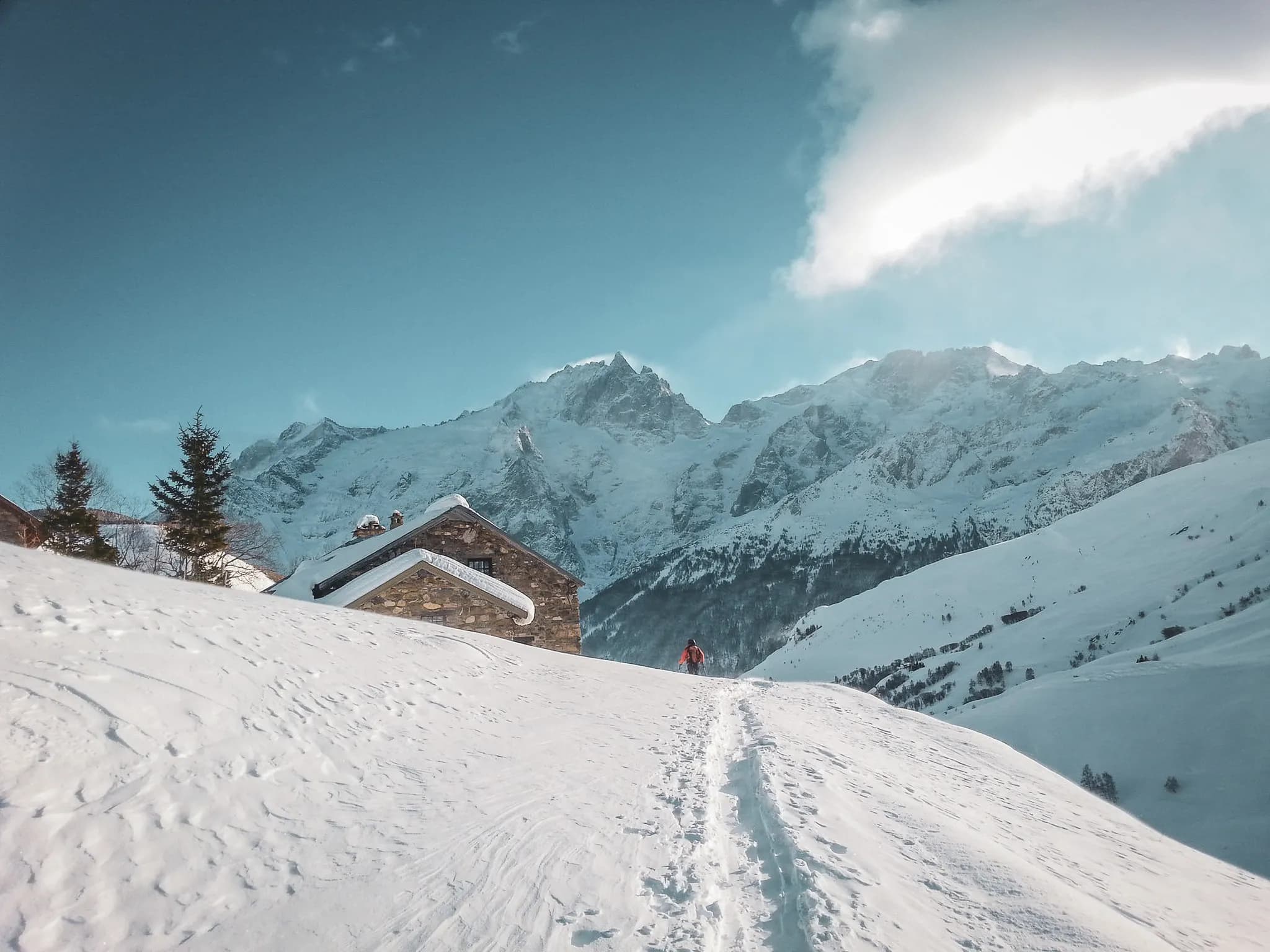 Een skiër waagt zich in een majestueus sneeuwlandschap, met gletsjertoppen op de achtergrond.