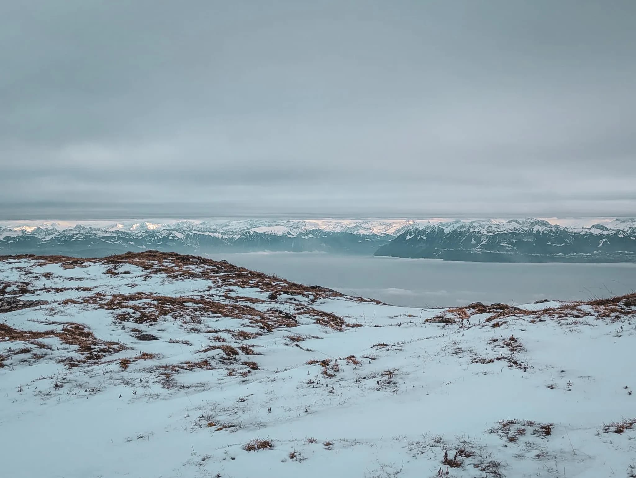 Het besneeuwde landschap van de Zwitserse Jura, met zijn majestueuze pieken en grijze luchten, nodigt uit om te ontsnappen.