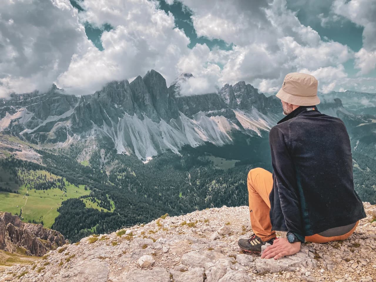 A man admiring the majestic peaks of the Dolomites, surrounded by enchanting scenery.