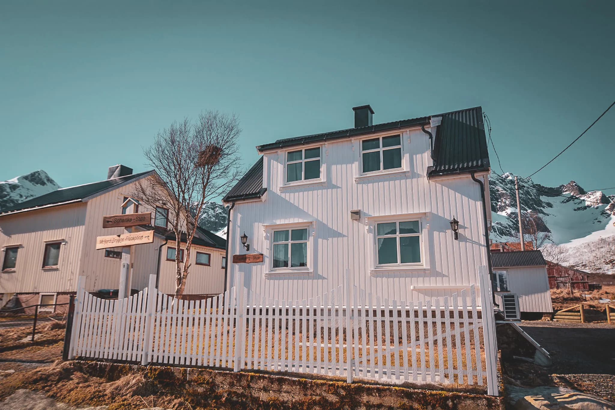 A charming white house on the island of Senja, surrounded by majestic mountains and unspoilt nature.