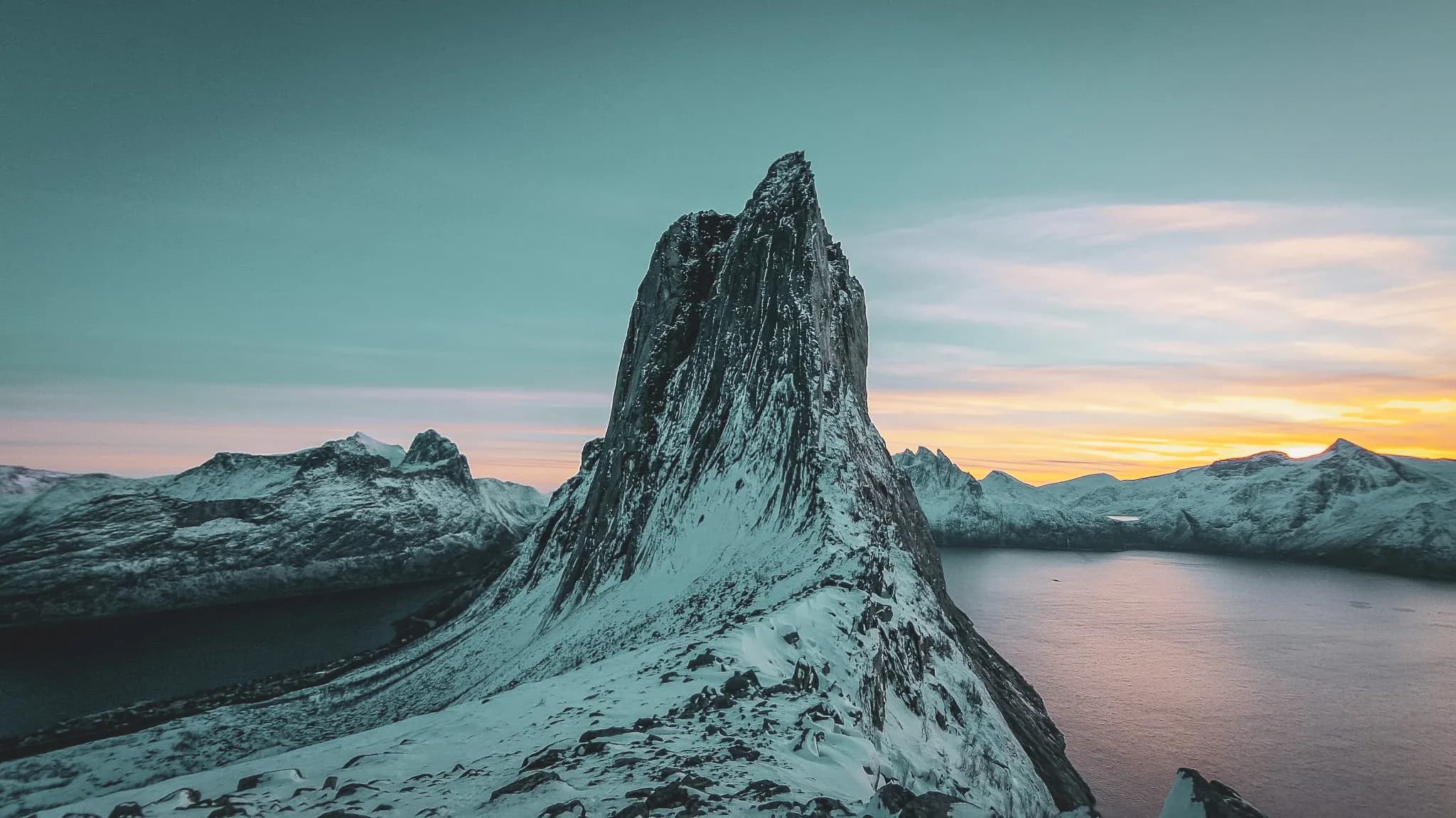 Snow-capped mountains reflected in a fjord at sunset, the wild beauty of Senja.