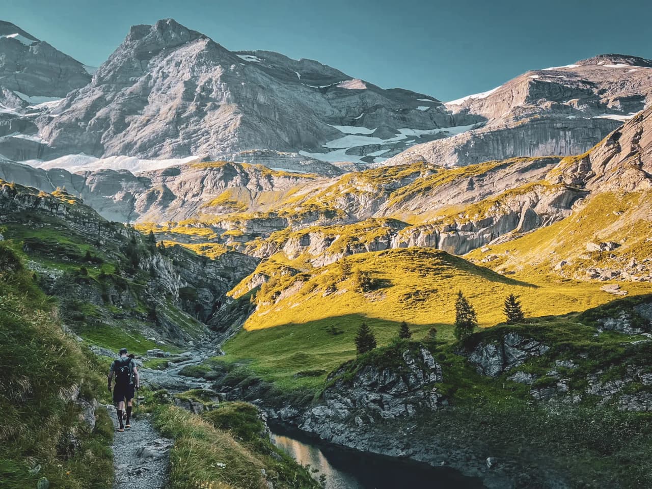 Hiking in the Alps, winding path with majestic mountains in the background.