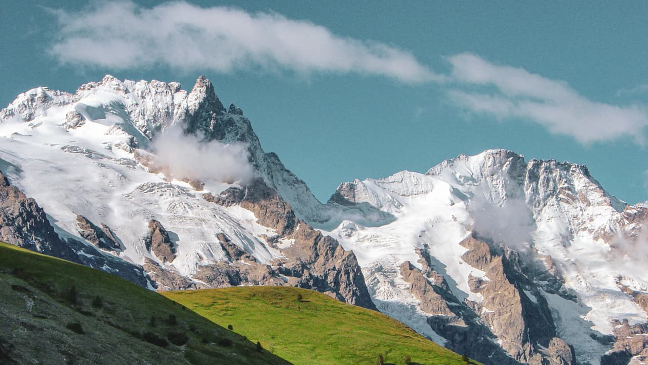 Majestic snow-capped mountains, lush greenery, blue skies: an invitation to alpine adventure.