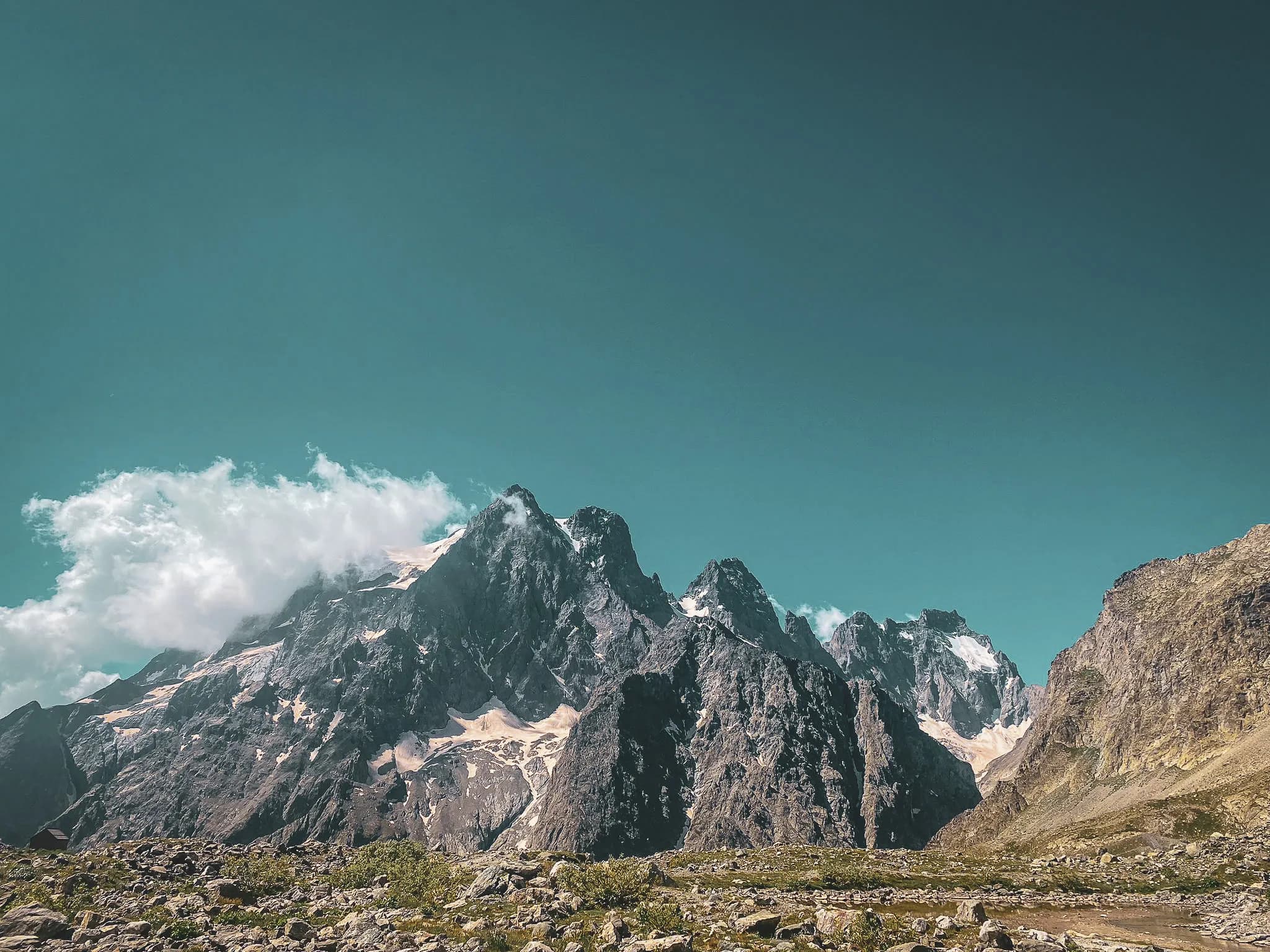 Majestueuses montagnes des Ecrins sous un ciel bleu, invitant à l'aventure alpine.