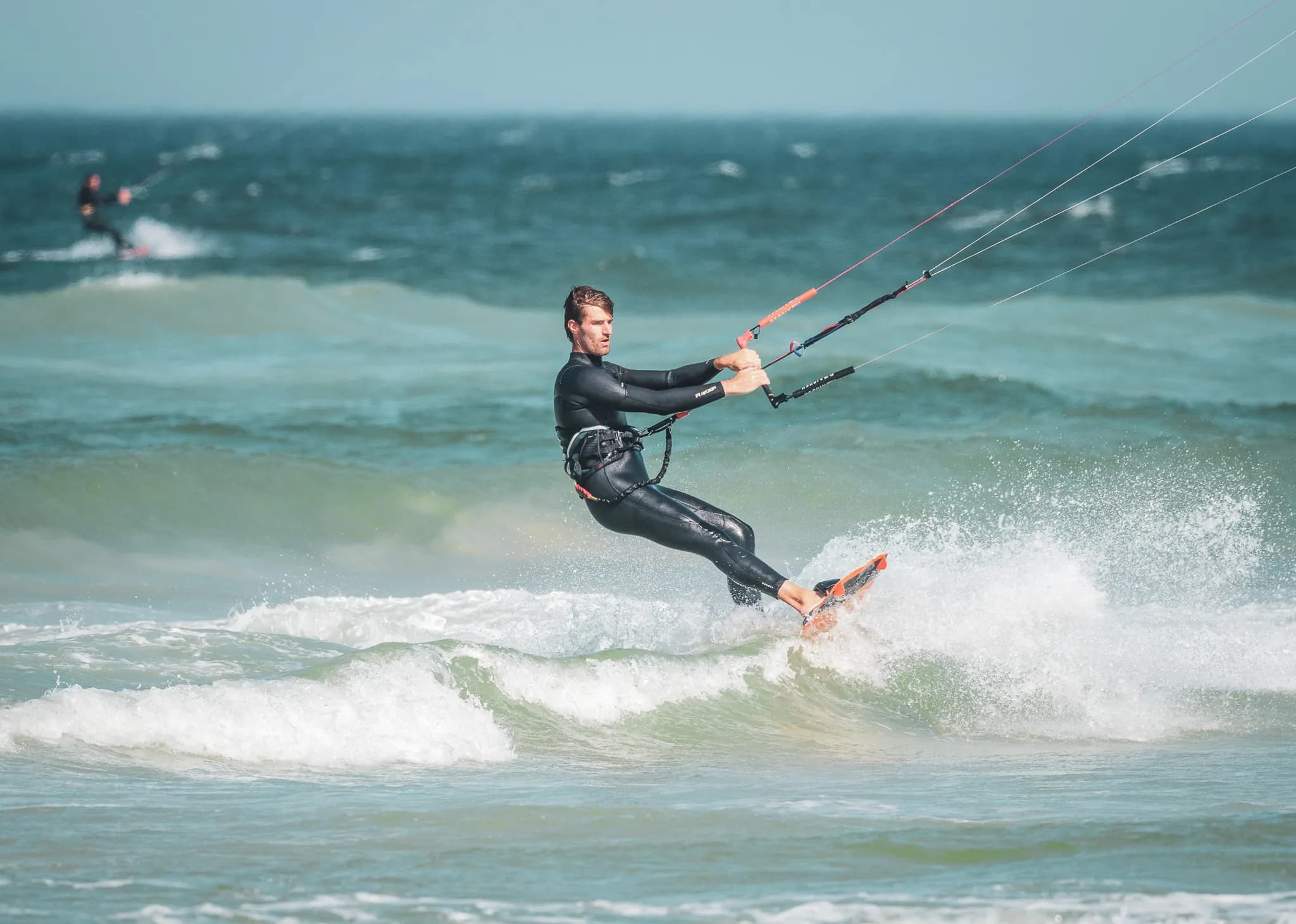 Un kitesurfeur vogue sur les vagues cristallines, explorant les beautés des Cyclades.