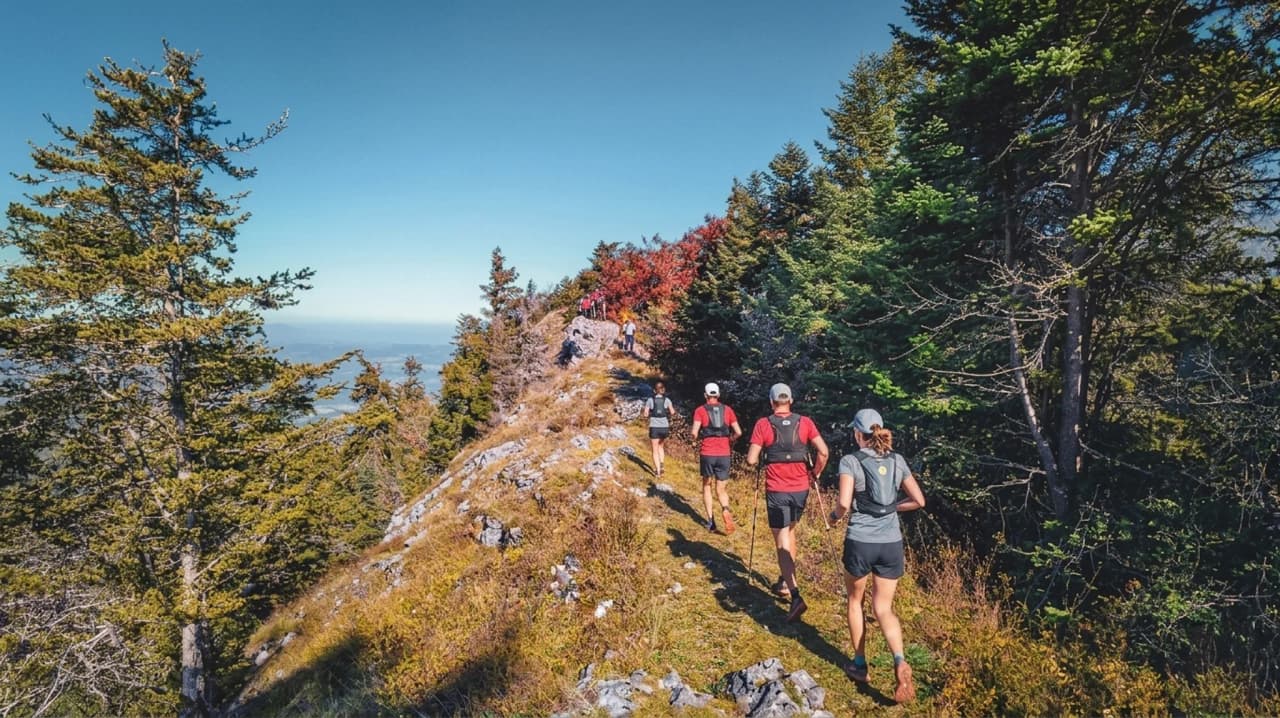 Randonneurs sur une crête ensoleillée, entourés de nature magnifique et de panoramas à couper le souffle.