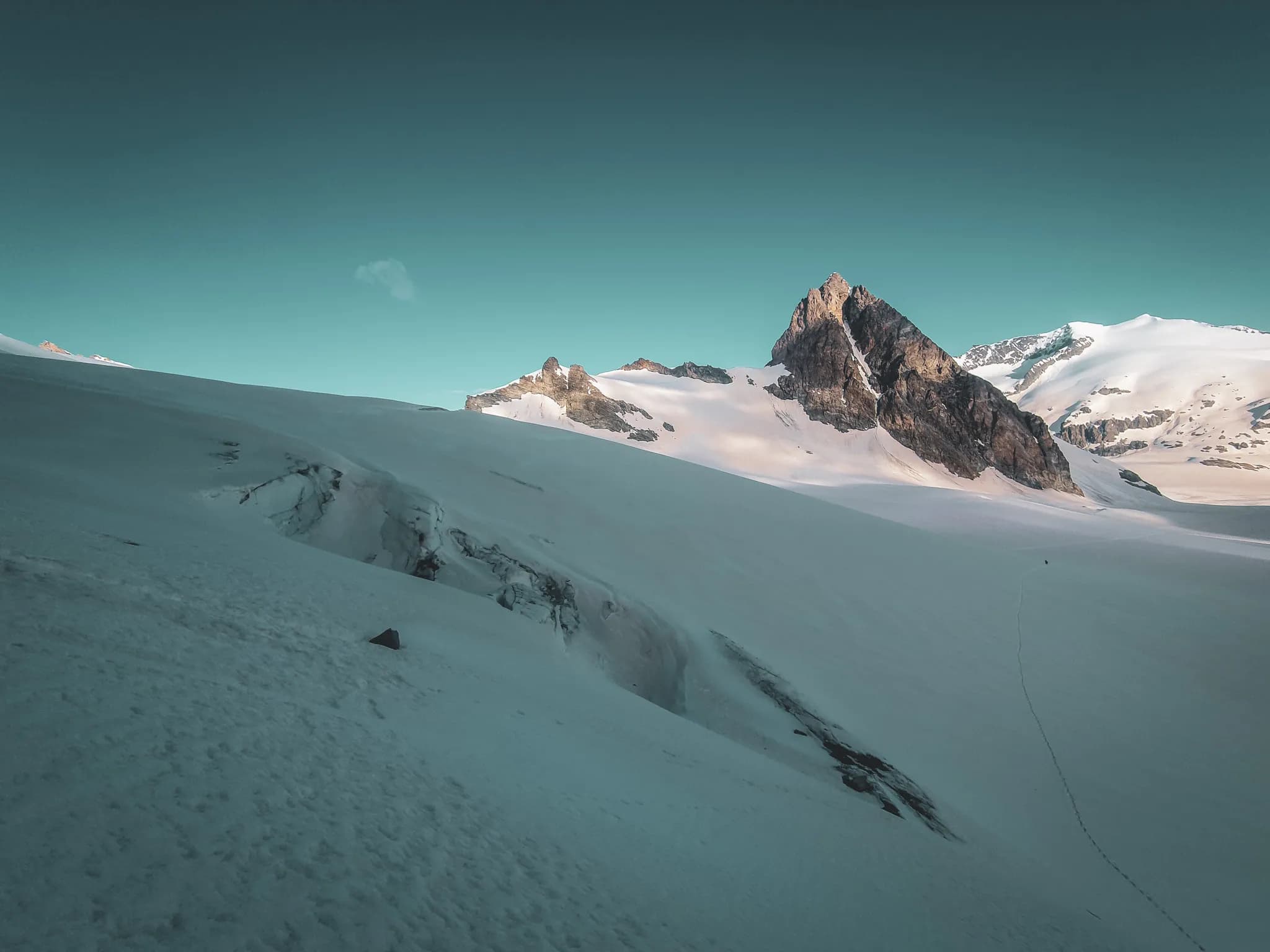 A vast glacial expanse with majestic peaks under a clear blue sky.