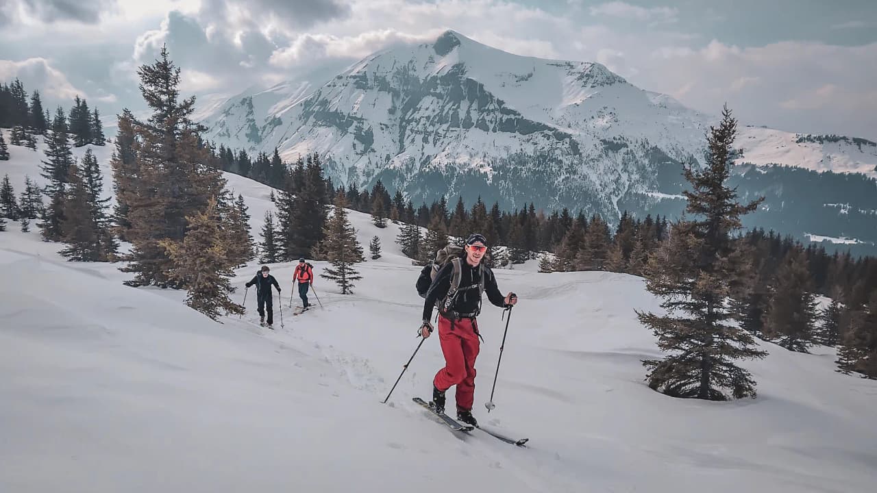 Hikers on skis amid snow-covered landscapes, with the majestic Mont Blanc in the background.