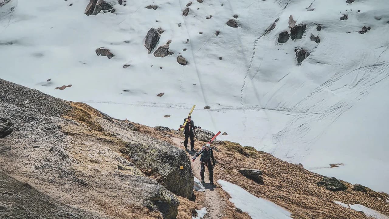 Two ski tourers cross a snow-covered mountain landscape, ready to climb Mont Blanc.