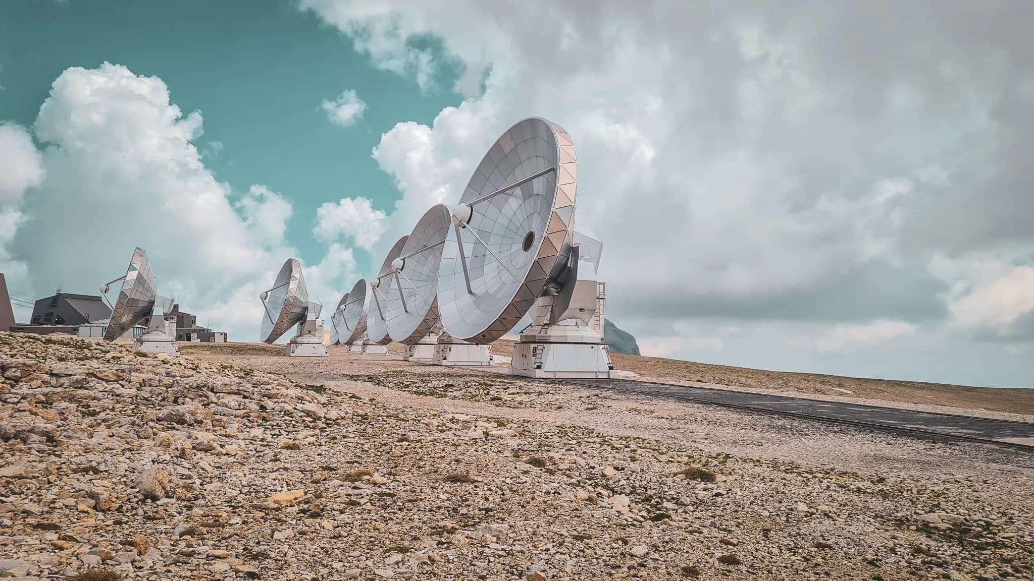 A glimpse of the antennae in the middle of nowhere, under a blue sky dotted with clouds, a fascinating Alpine landscape.