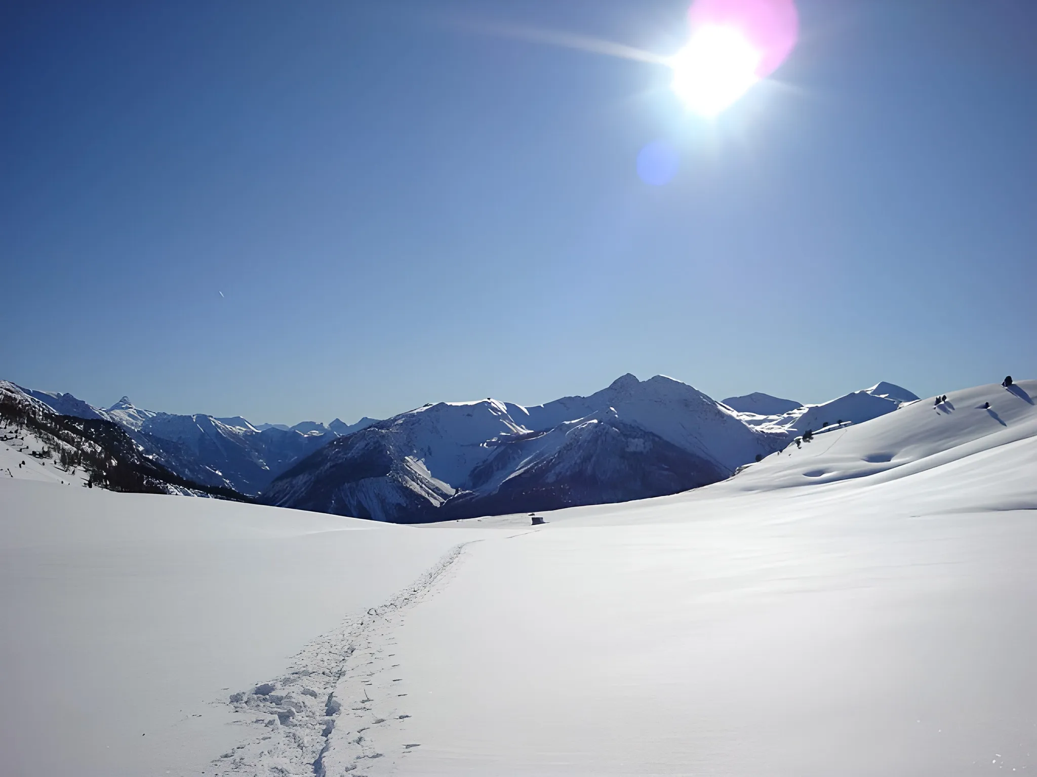 Snow-covered mountain scenery under a brilliant blue sky, inviting you to embark on a snowshoeing adventure.