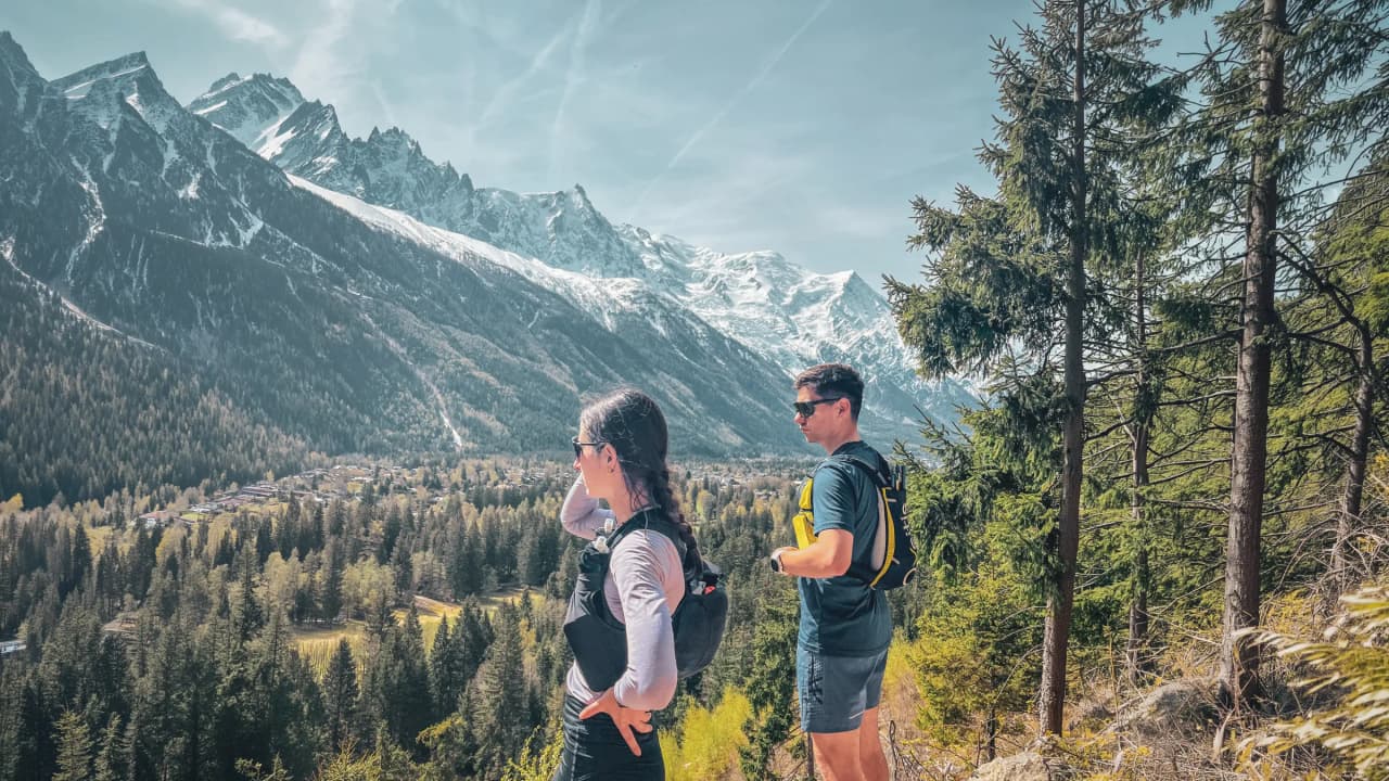 Twee wandelaars bewonderen het spectaculaire uitzicht op de bergen en bossen van Chamonix.