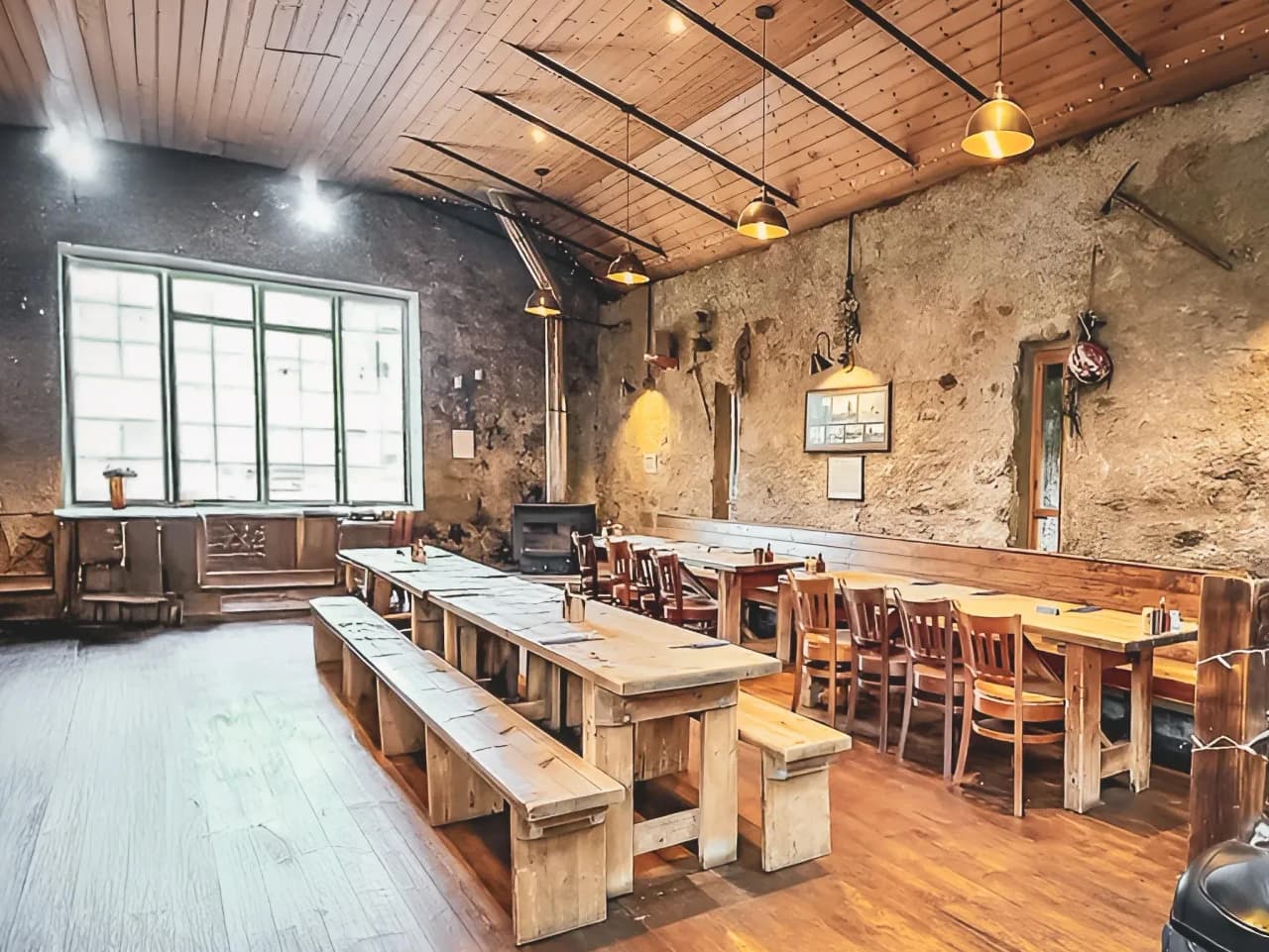 Een rustieke en gezellige ruimte met houten tafels, badend in het licht, perfect voor een maaltijd na een avontuur.