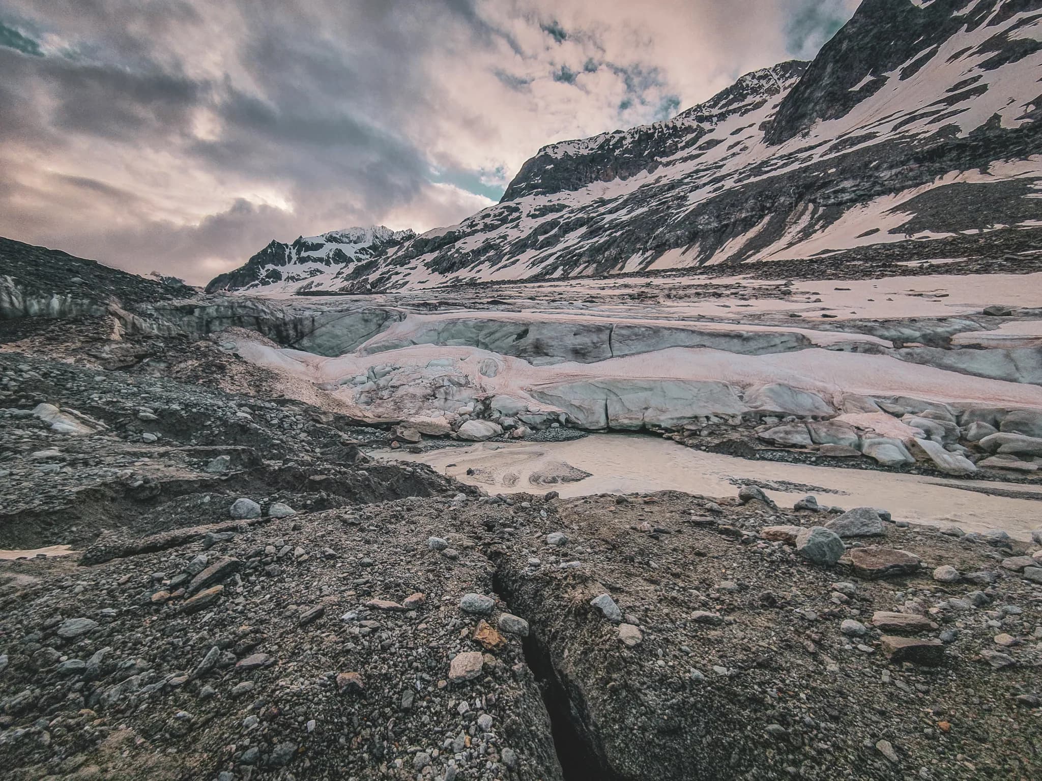 A majestic glacial landscape of alpine mountains, glaciers and rock formations.