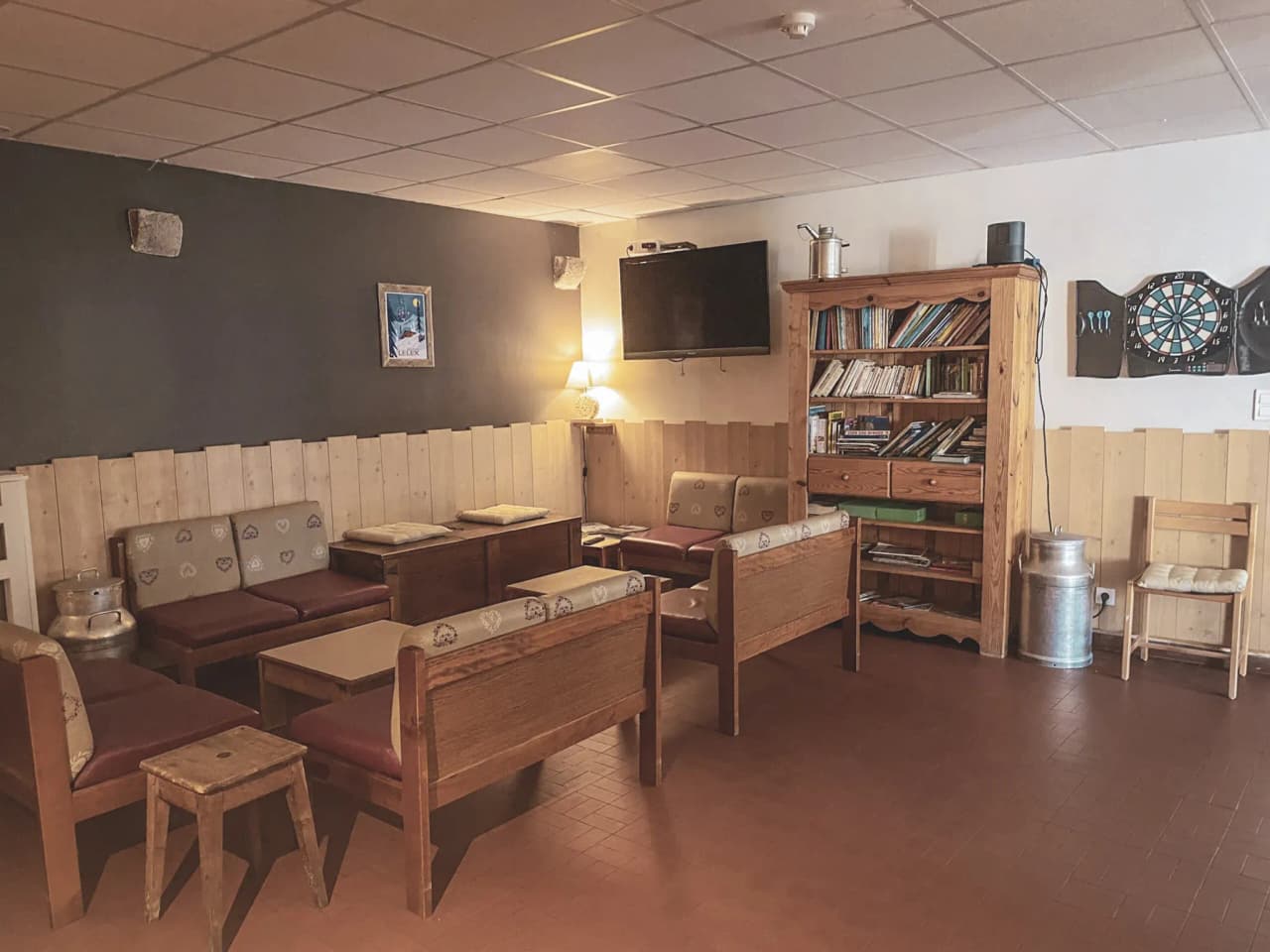 A cosy lounge with wooden sofa, bookcase and warm atmosphere, ideal for relaxing after an adventure.