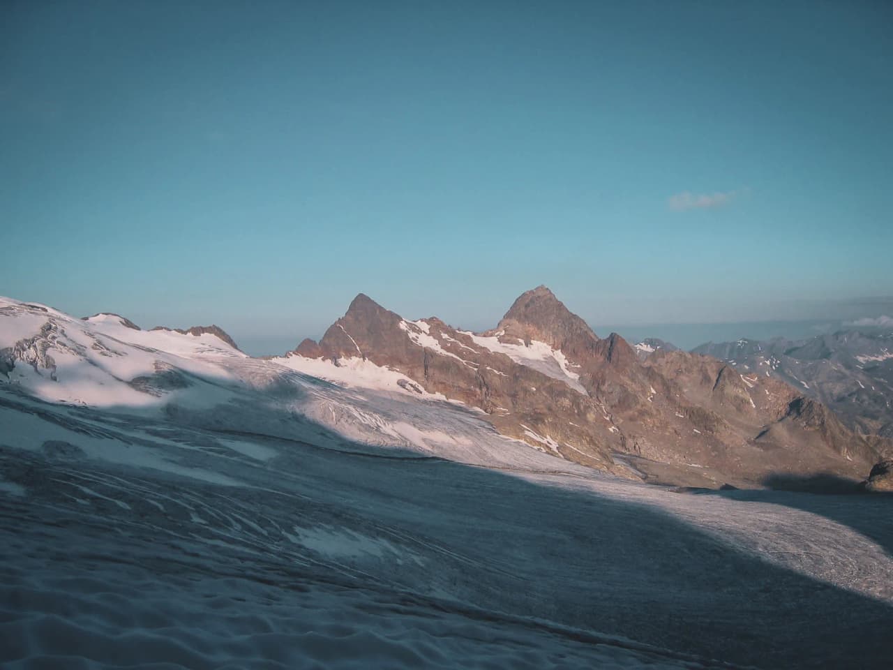 Vue majestueuse sur le glacier, montagnes dominantes et ciel bleu, invitation à l'aventure alpine.