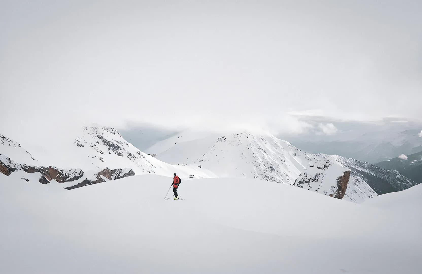 Wandelaar in een besneeuwd berglandschap.