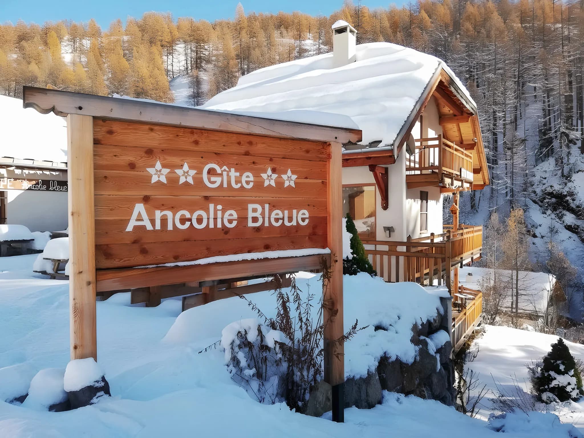 Ancolie Bleue gîte under a blanket of snow, surrounded by majestic golden fir trees. A haven of peace!