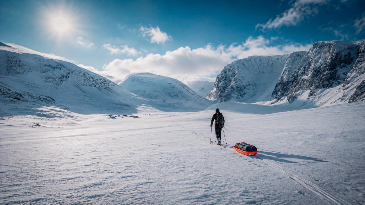 Een eenzame skiër doorkruist de majestueuze besneeuwde landschappen van Zweeds Lapland.