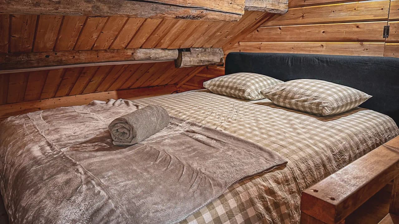 Een gezellige houten slaapkamer met een zacht bed om nieuwe energie op te doen na een avontuur in Lapland.