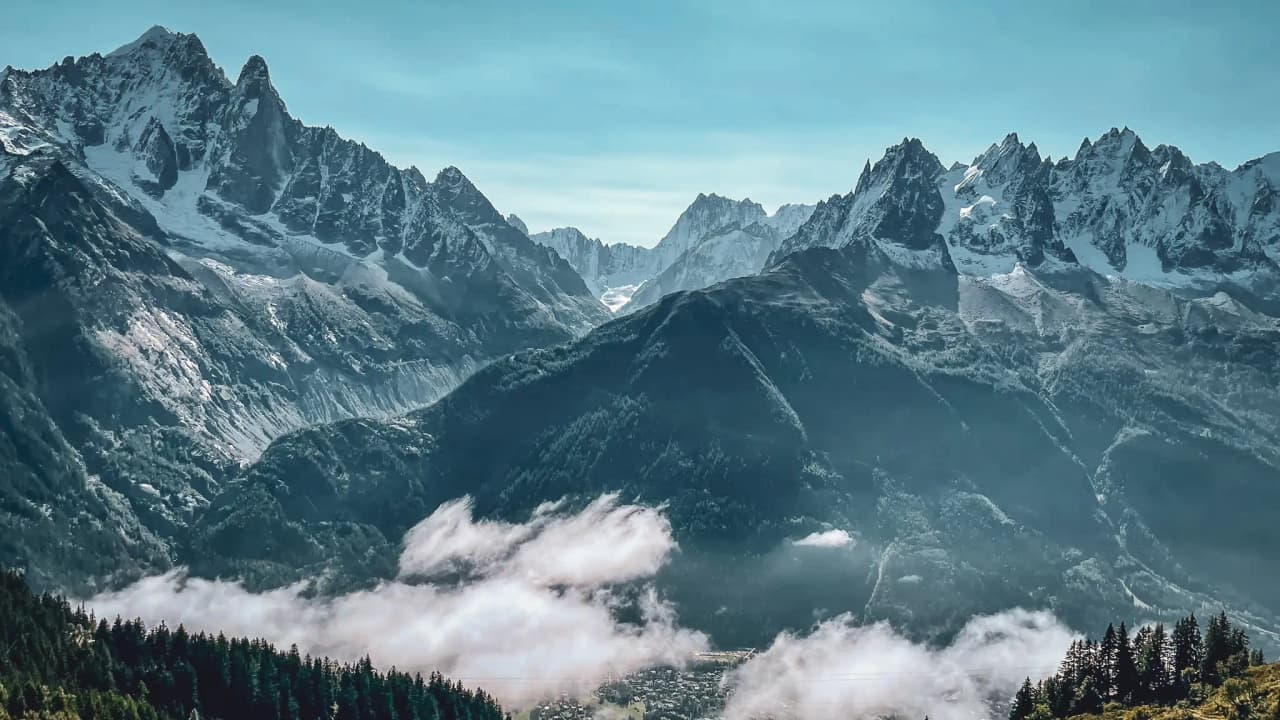 Spectaculair uitzicht op het Mont Blanc-massief, met majestueuze bergen en drijvende wolken.