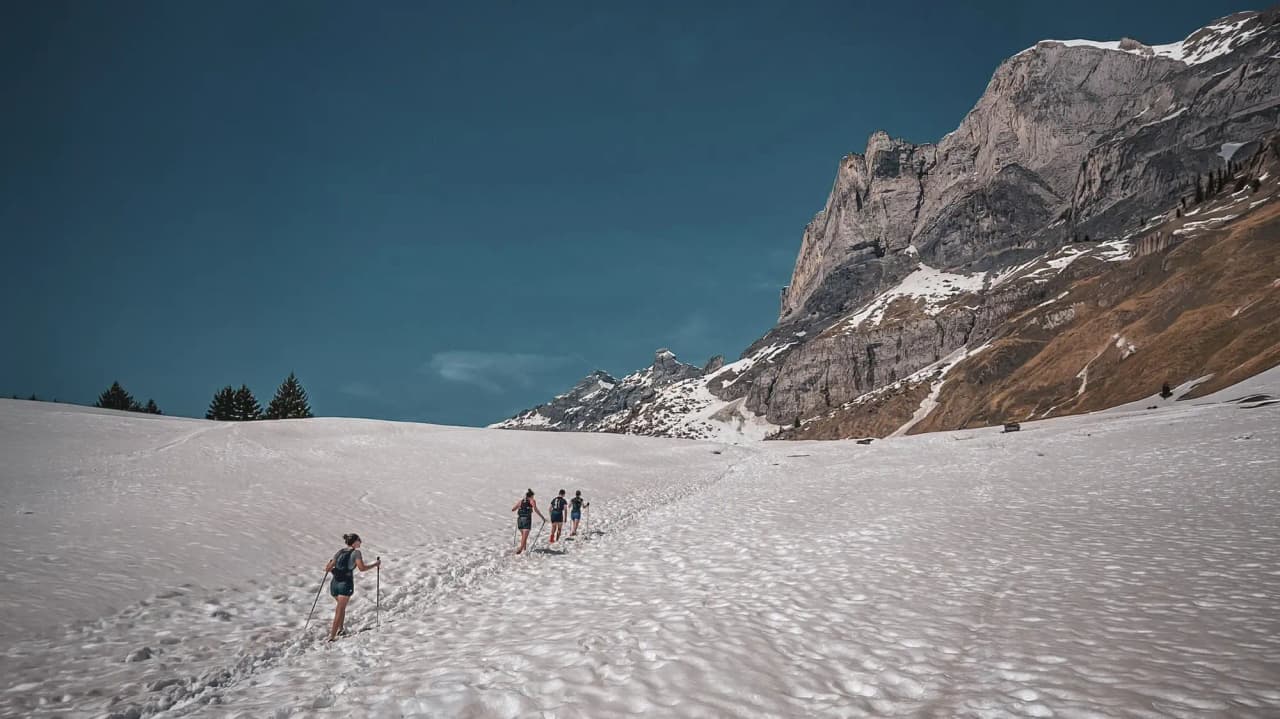 Een groep wandelaars op een besneeuwd pad, met uitzicht op de majestueuze bergen van Chamonix.
