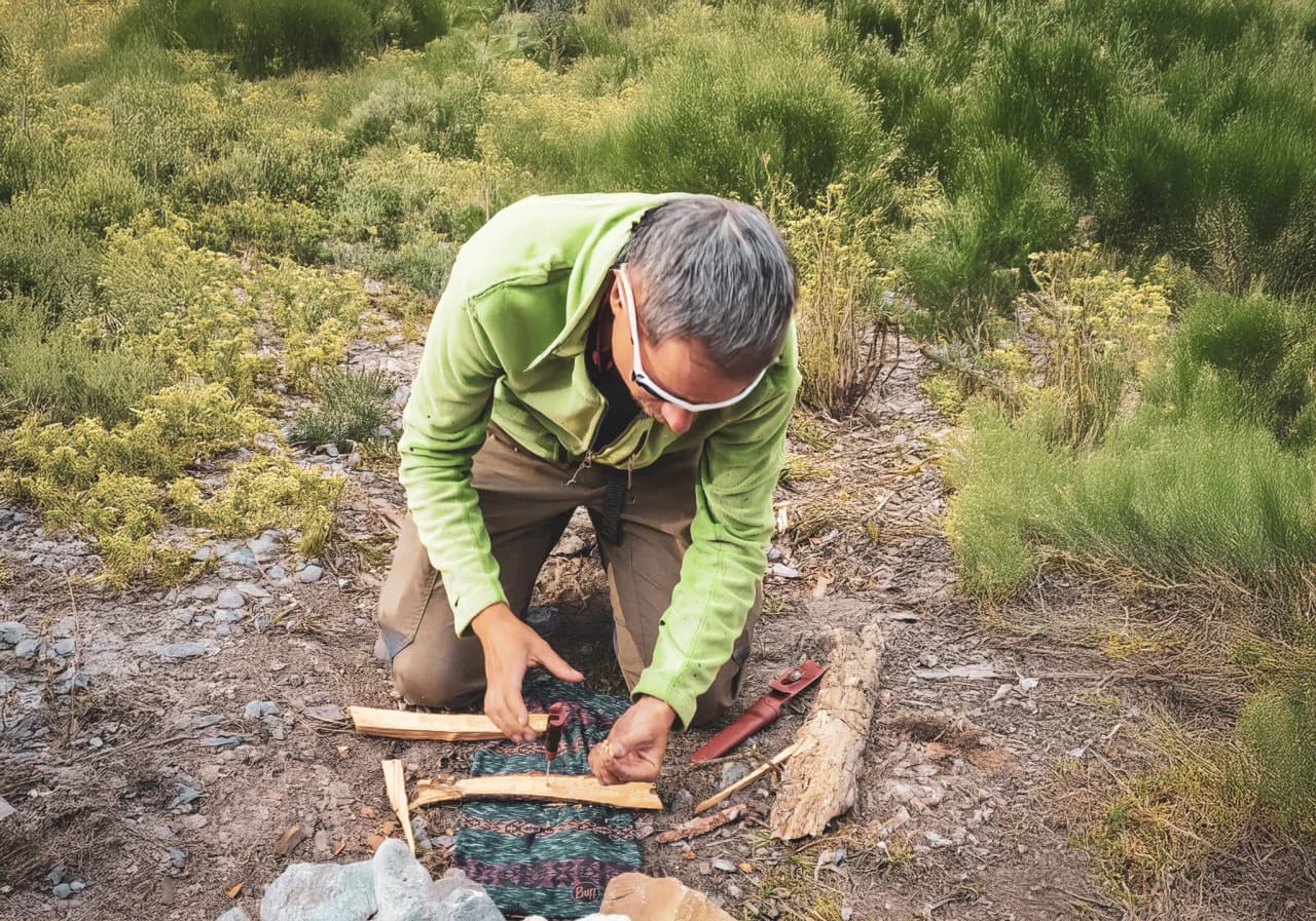 Homme en plein apprentissage de techniques de survie en pleine nature, dans les Alpes.