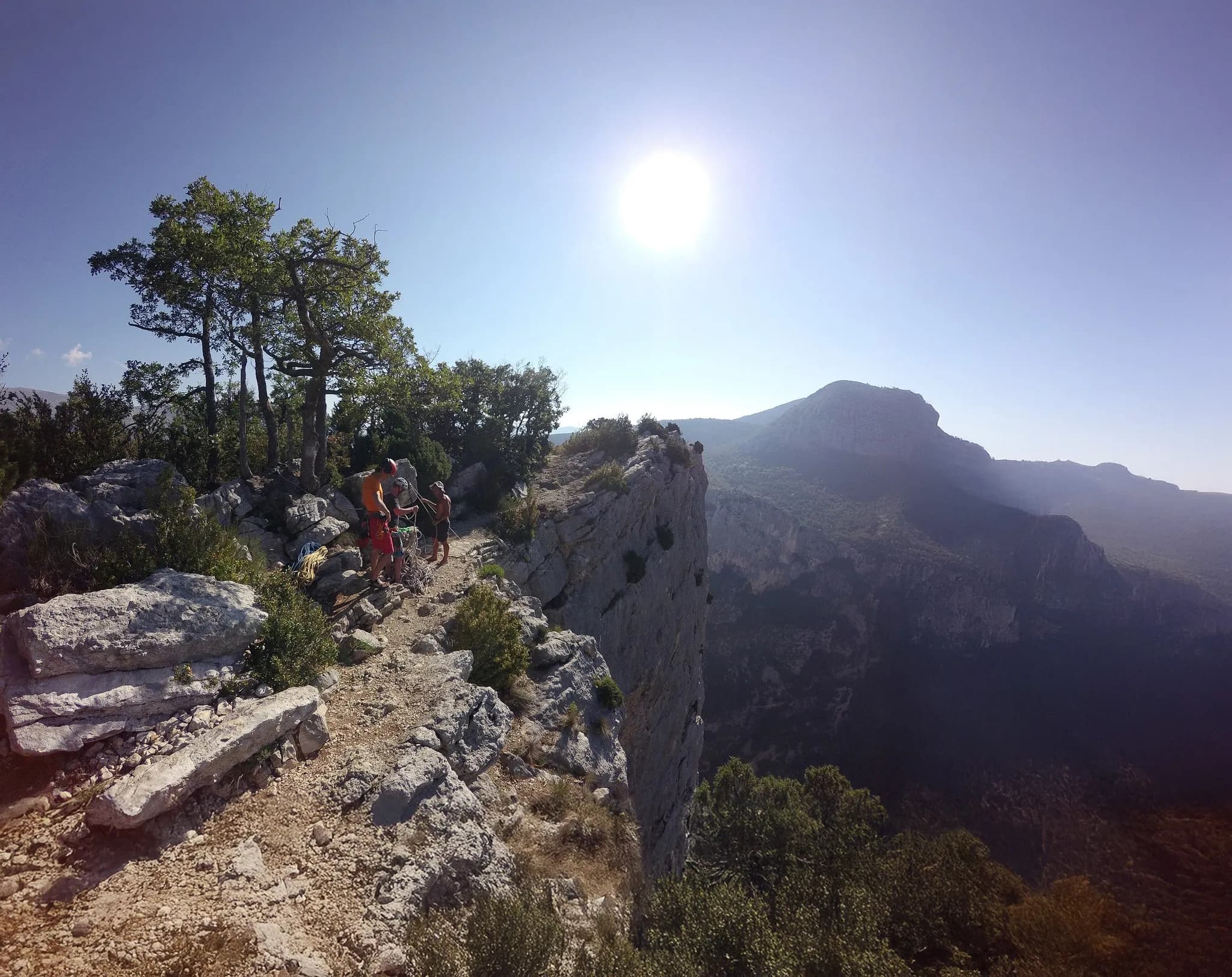 A group of climbers overlook the magnificent Gorges du Verdon under a sunny sky.