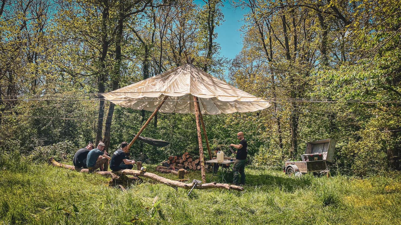 Groupe en pleine activité de survie sous un abri en pleine forêt verdoyante.