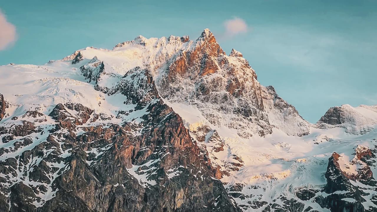 Aperçu des majestueuses Aiguilles d'Arves, sommet alpin sous un ciel éclatant.