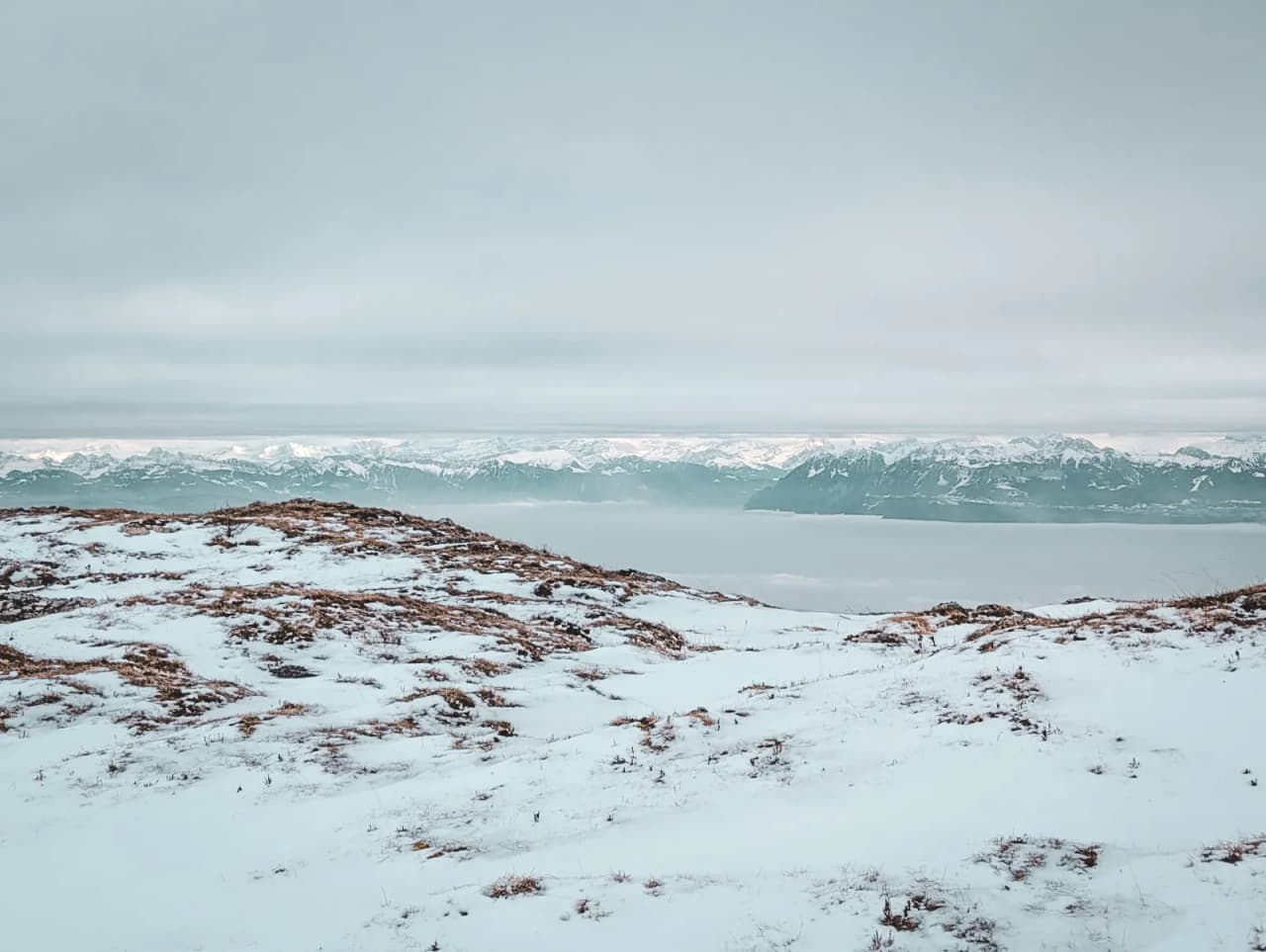 Panorama hivernal sur les montagnes du Jura, recouvertes de neige, parfait pour l'évasion.